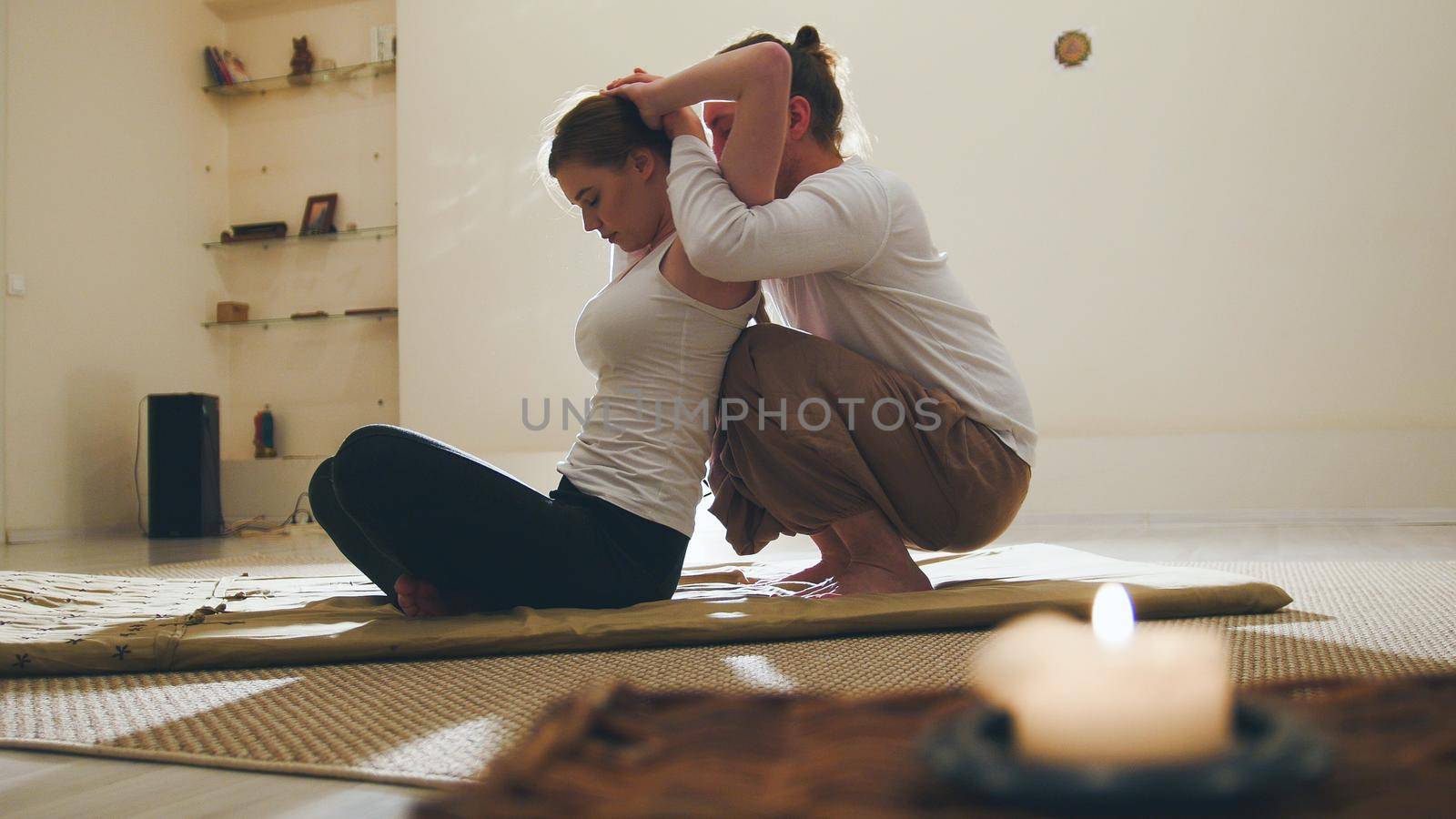 Massage session in candles - traditional thailand therapy for young female model, telephoto