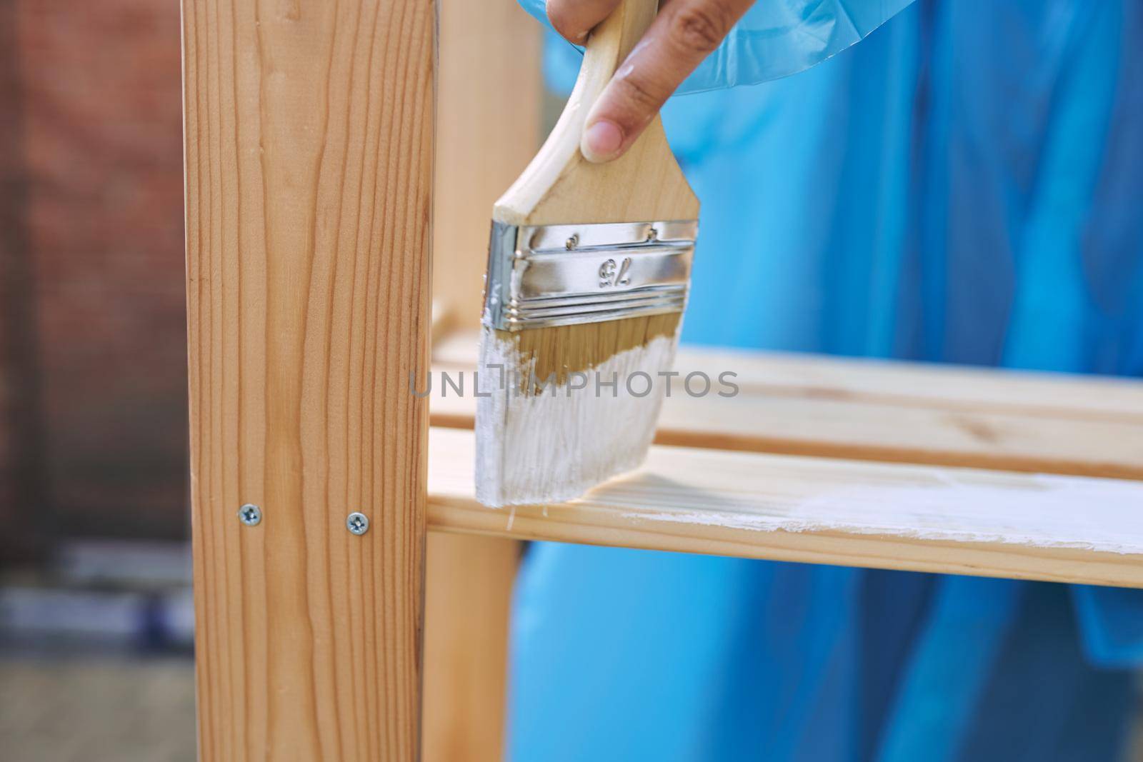 woman in protective suit painting wood renovation design. High quality photo