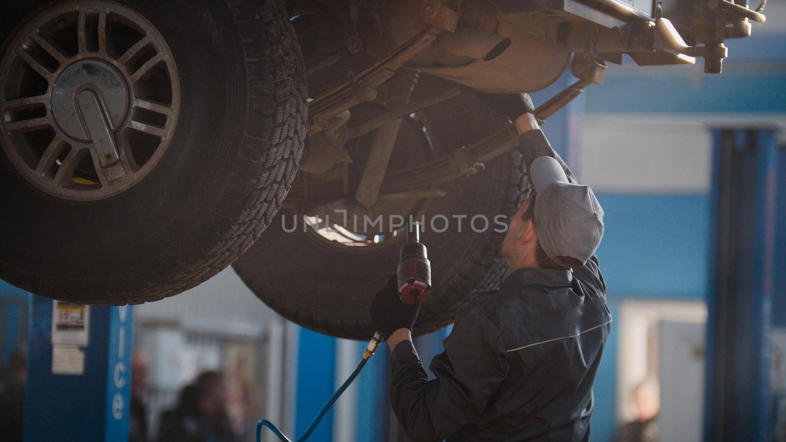 Mechanic is checking the wheel in garage automobile service, telephoto