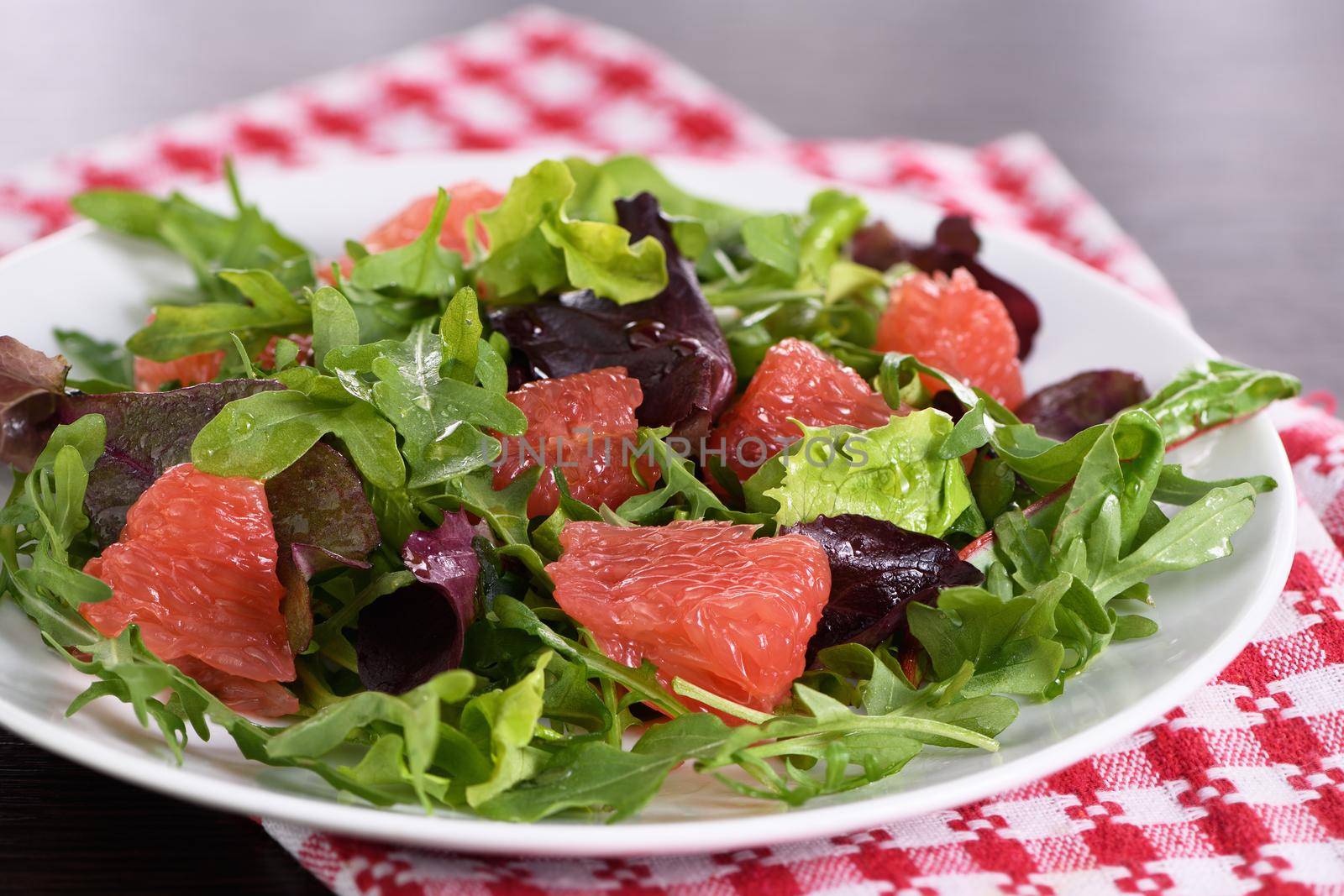 Grapefruit salad, a mix of lettuce, arugula and olive dressing. Dietary menu. Proper nutrition. Vegetarian food.