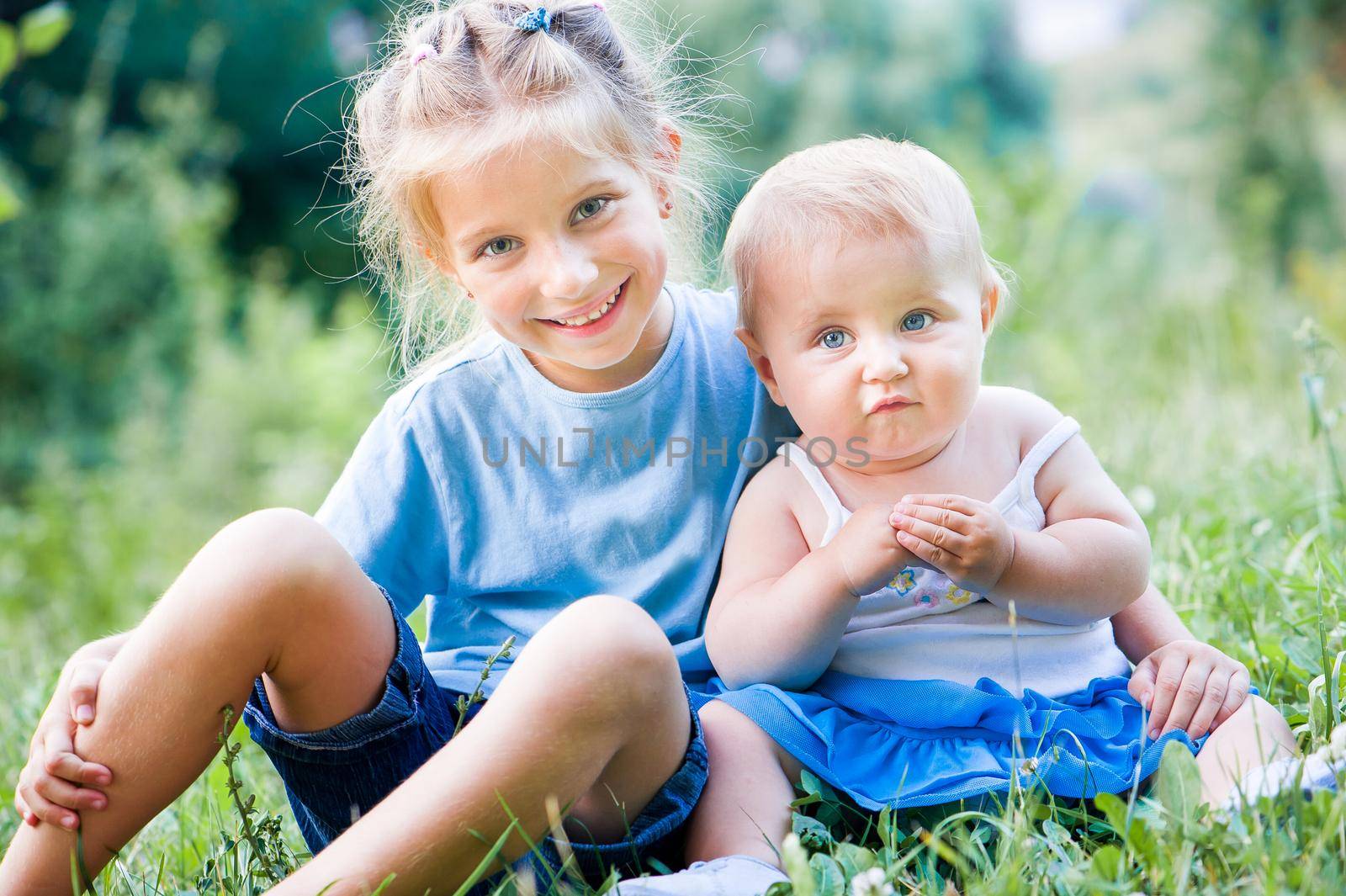 two lovely sisters in a meadow on a sunny summer day