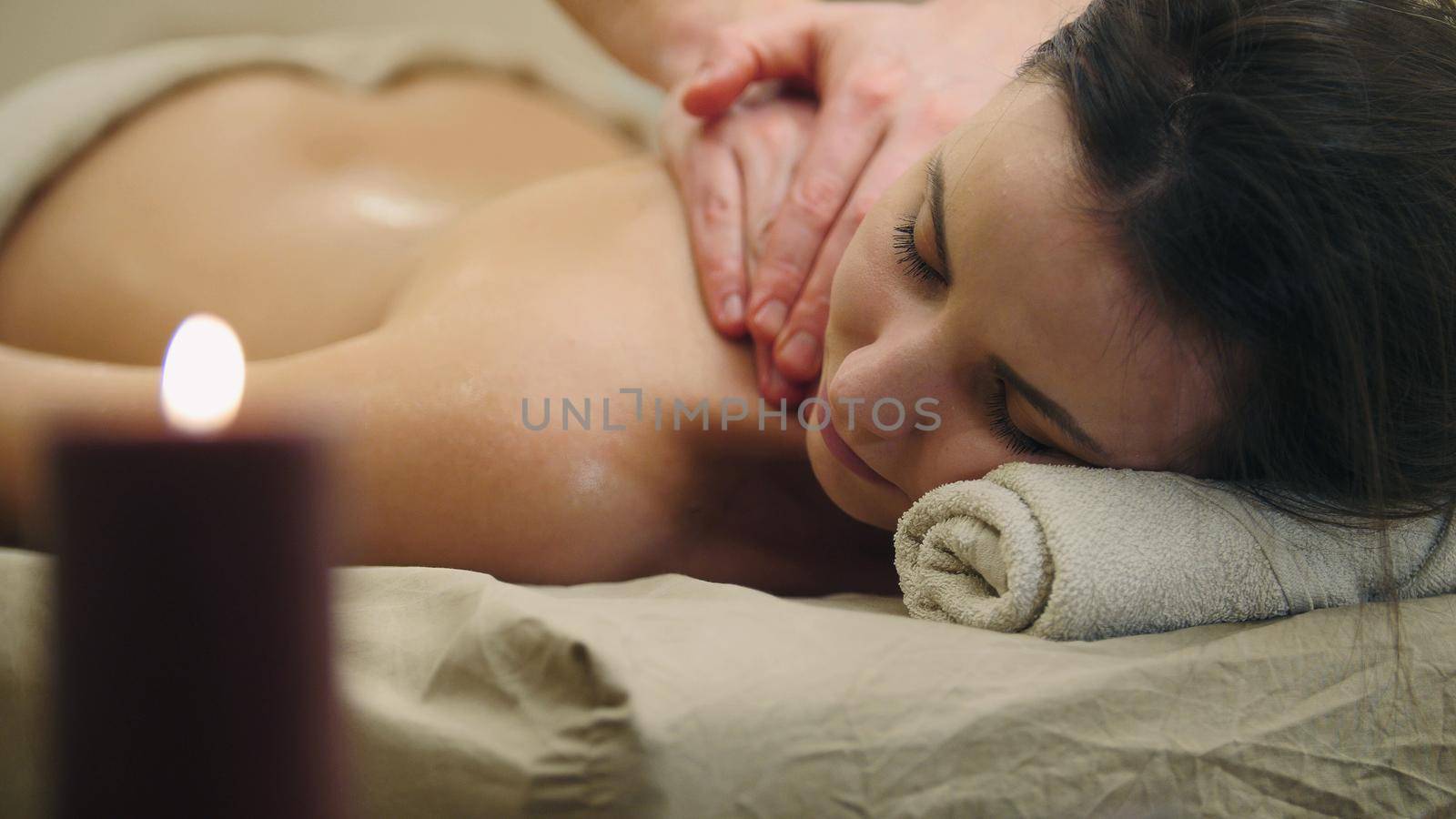 Half nude young female in massage table at spa salon - oil relax massage, spa concept, close up