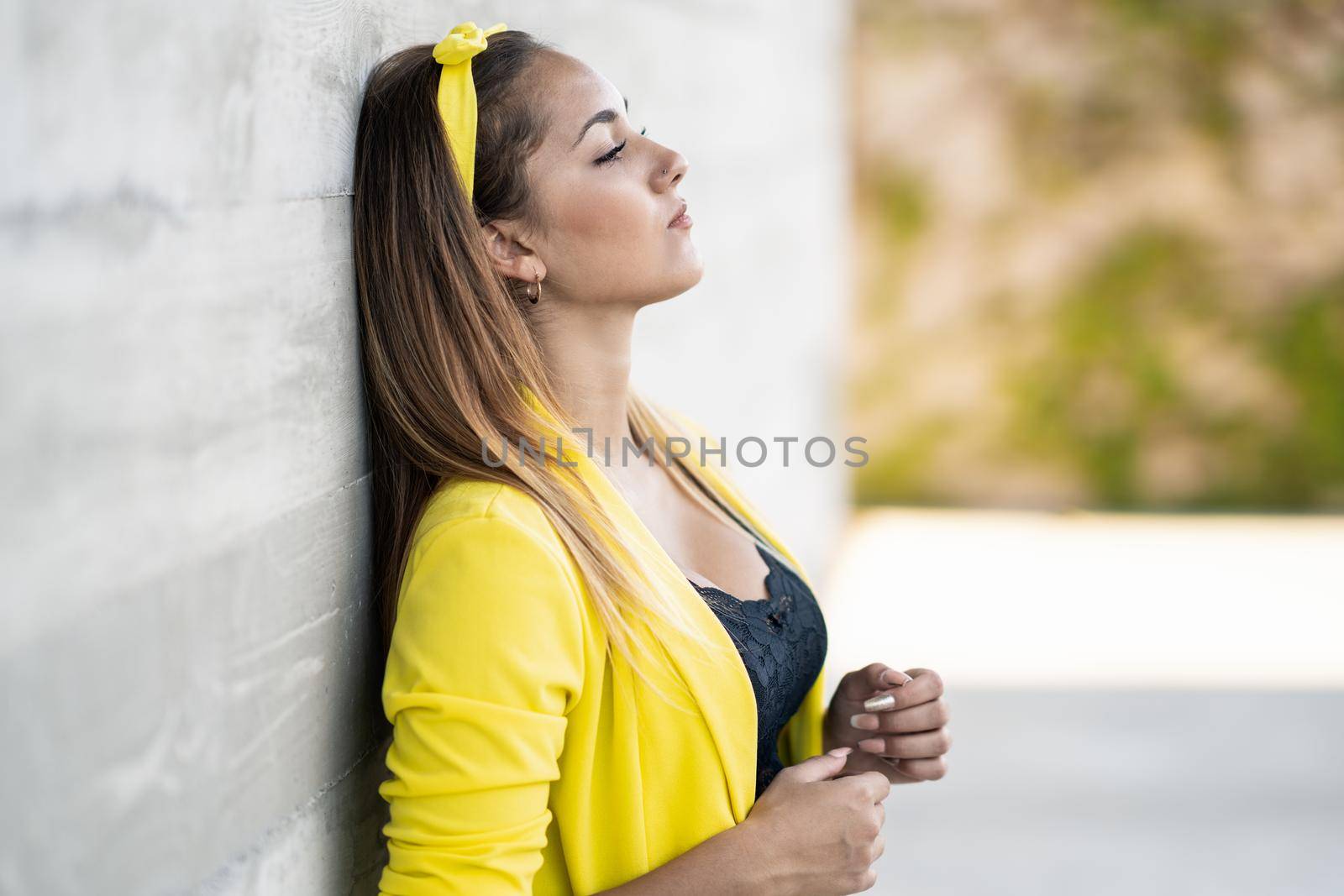 Young woman wearing a yellow jacket and headband outdoors