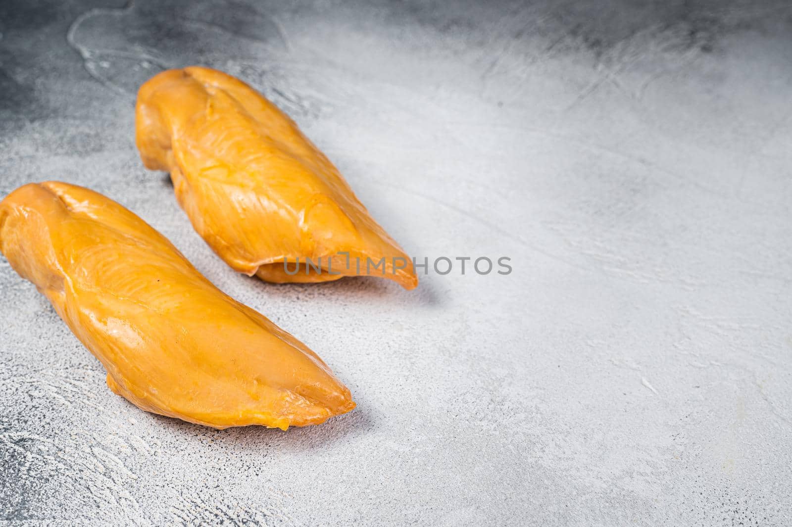 Smoked chicken breast fillet meat delicacy. White background. Top view. Copy space.