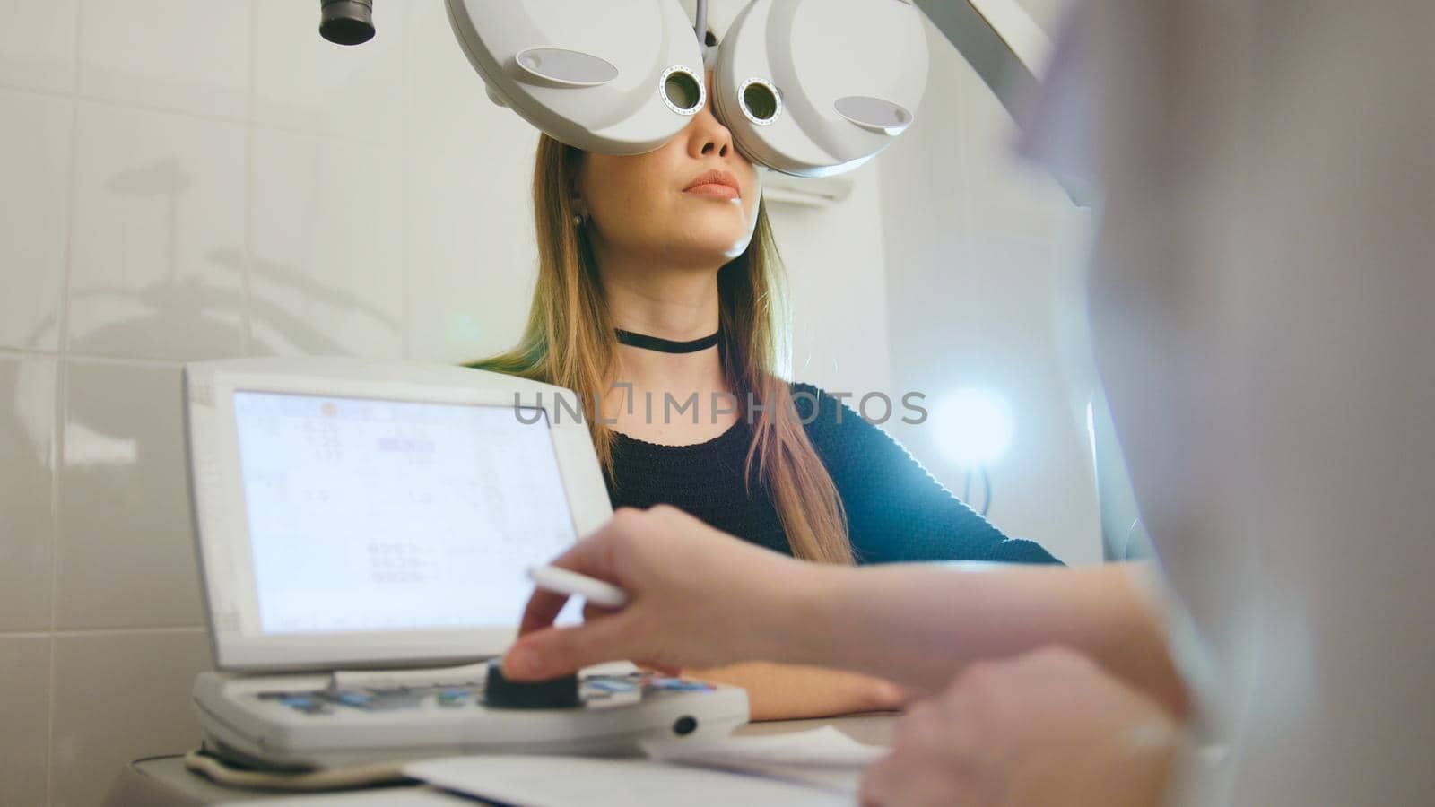 Woman doing eye test with optometrist in medical center, close up