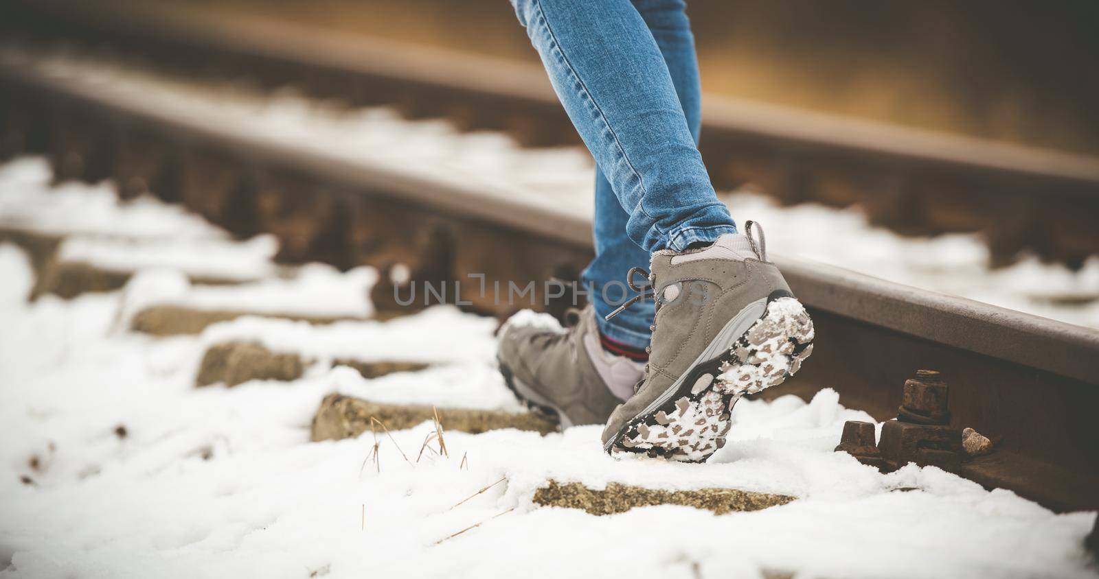 girl in boots walking on rails in winter