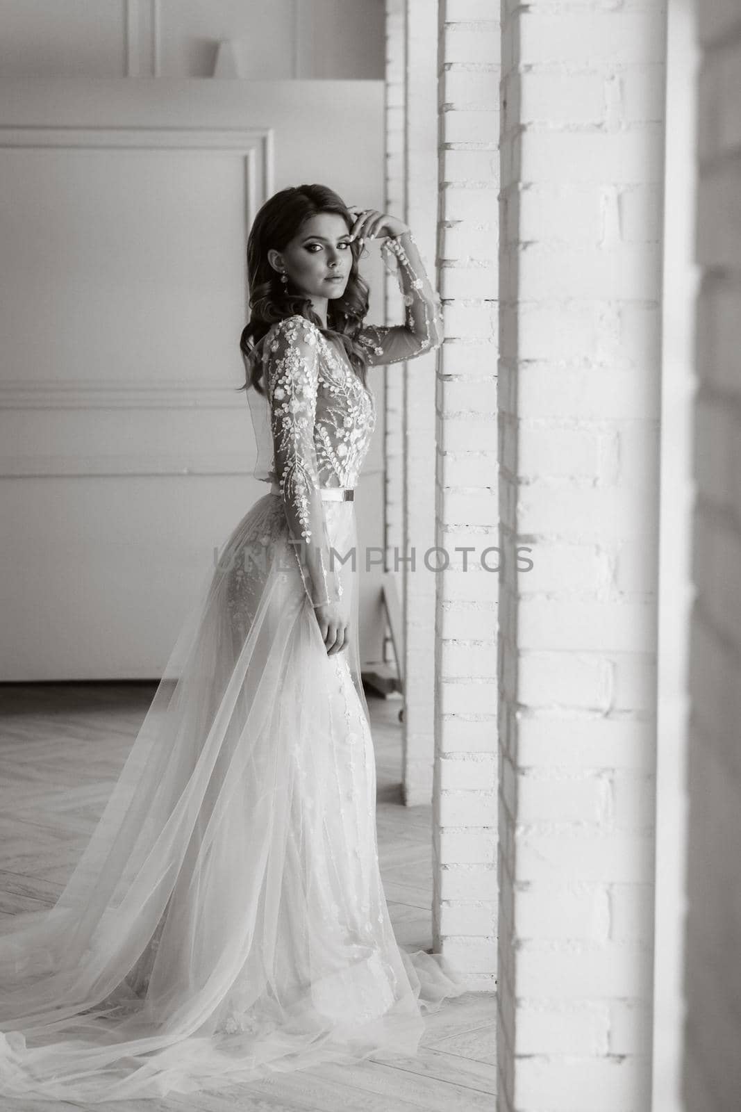 A luxurious bride in a wedding dress in the morning in her interior.Black and white photo.