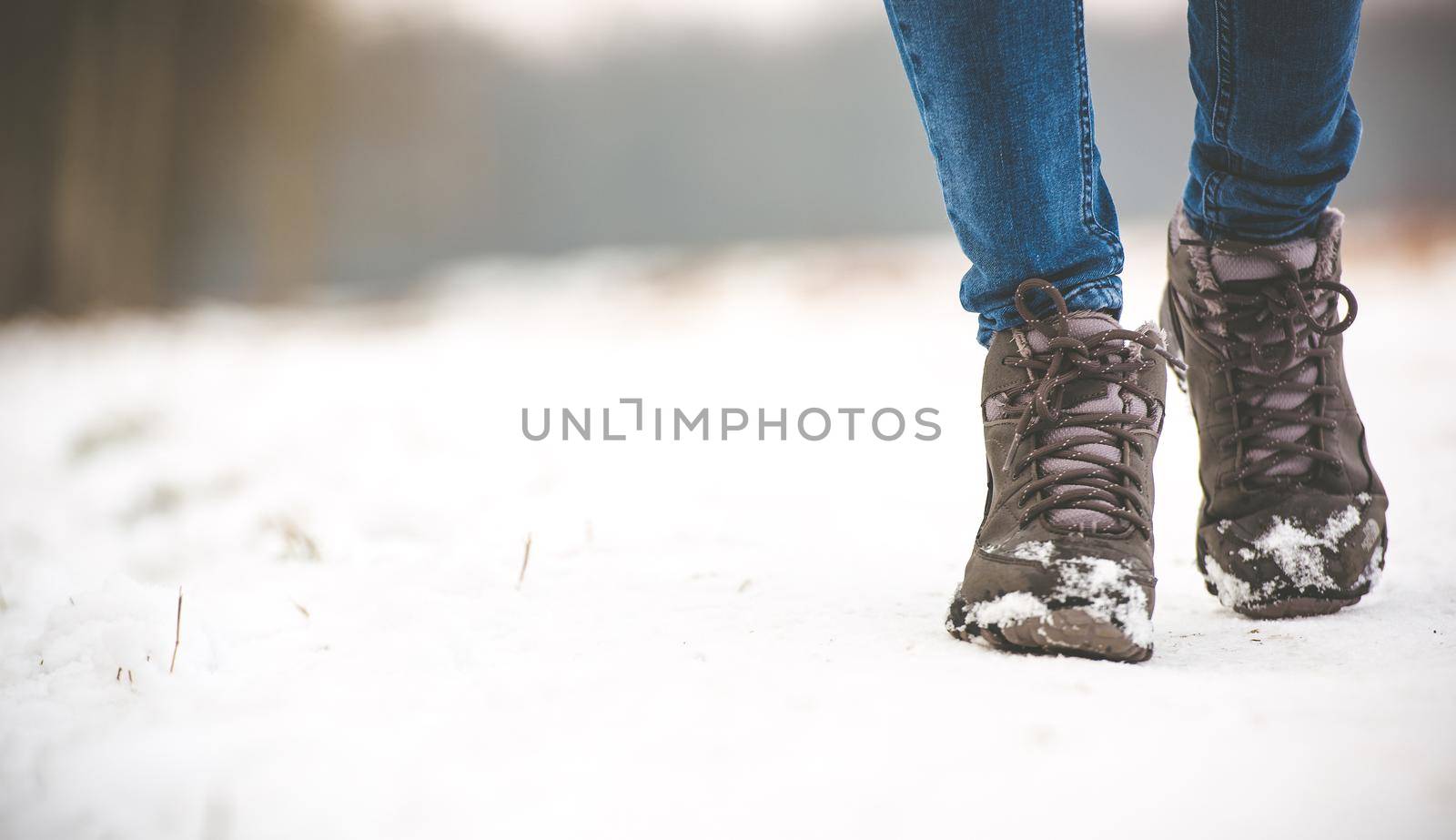 girl in winter boots walking on snowy road