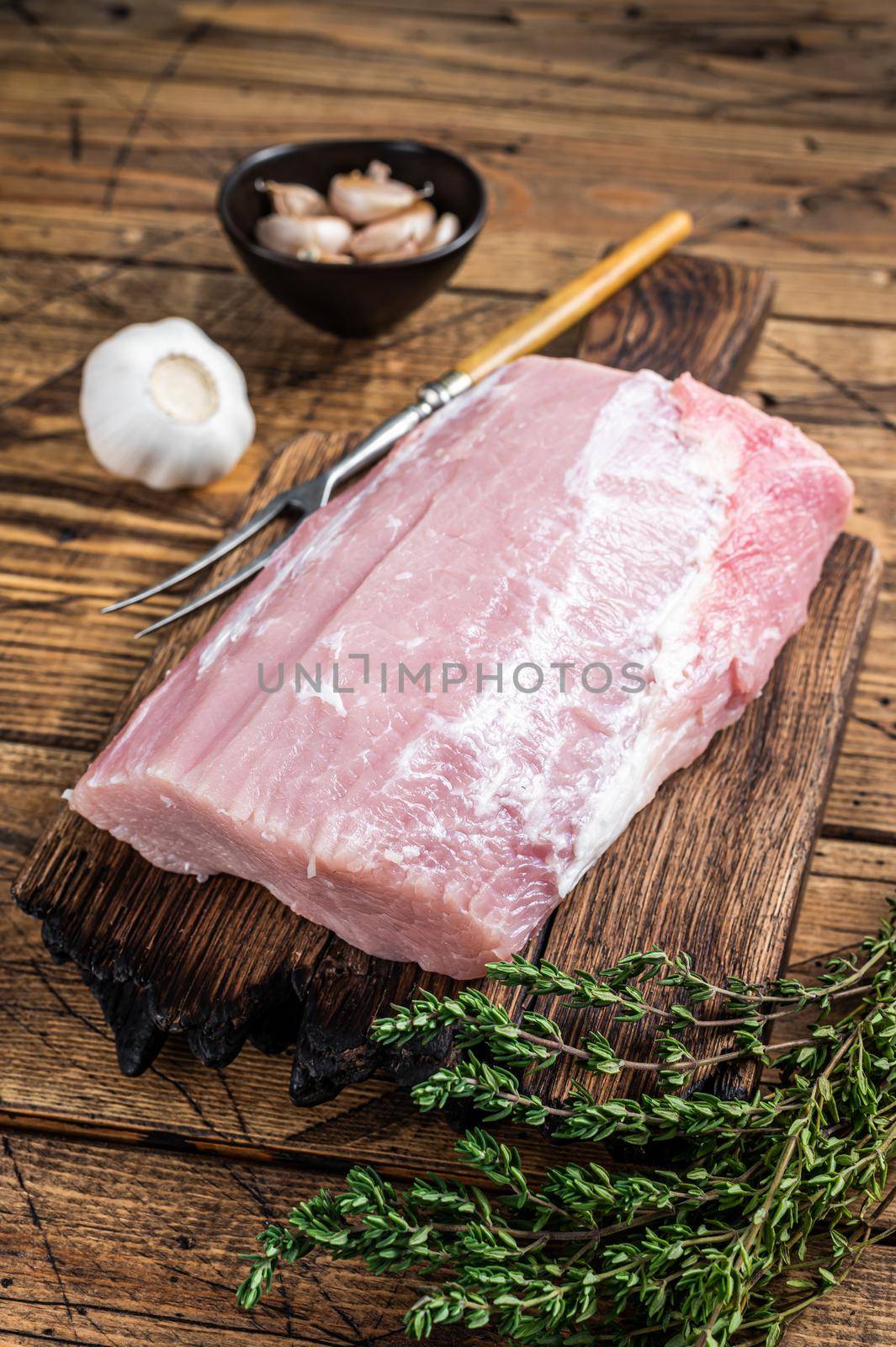 Raw pork loin with spices on wooden board. wooden background. Top view.