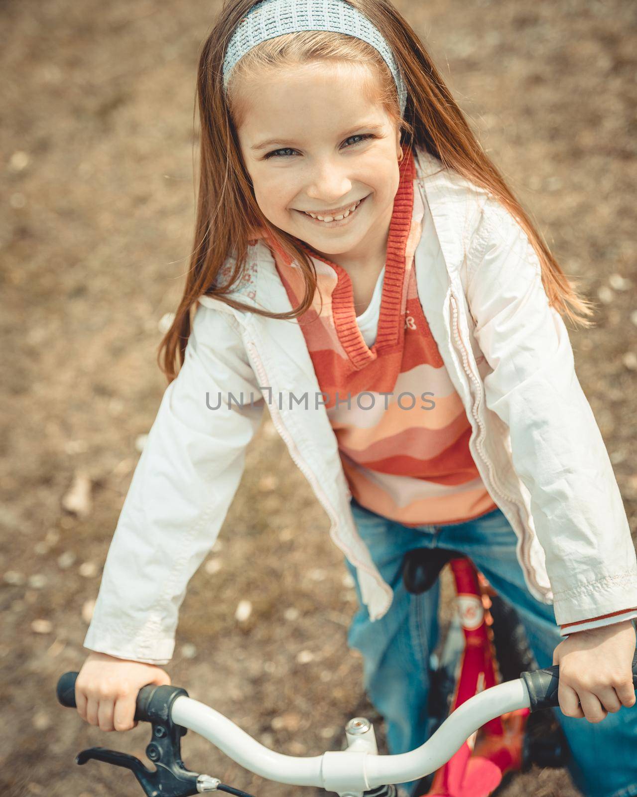 Little girl on a bicycle in summer park