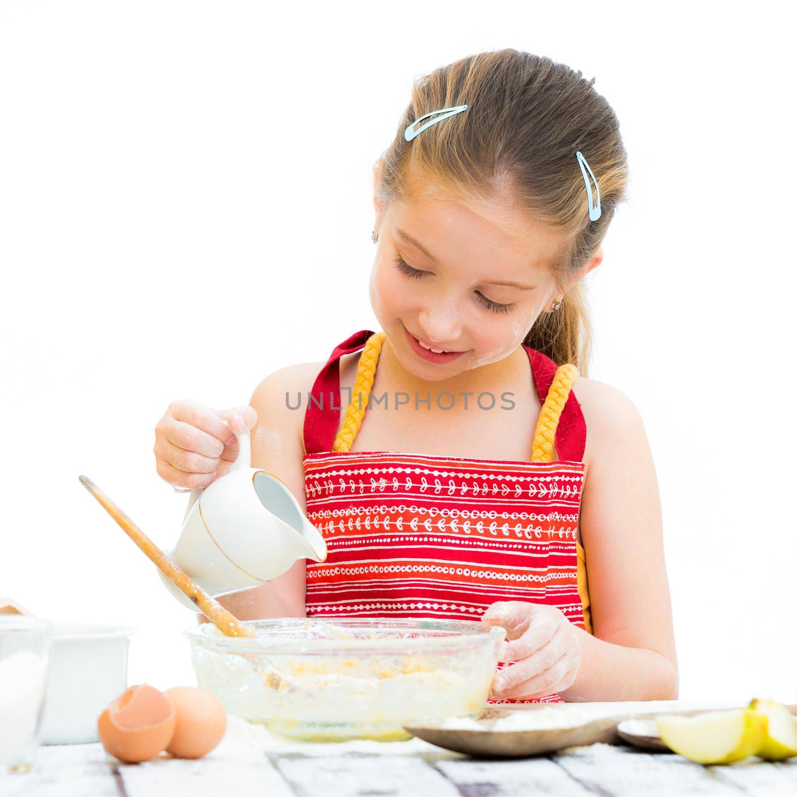 cutre little girl making dough isolated on a white background