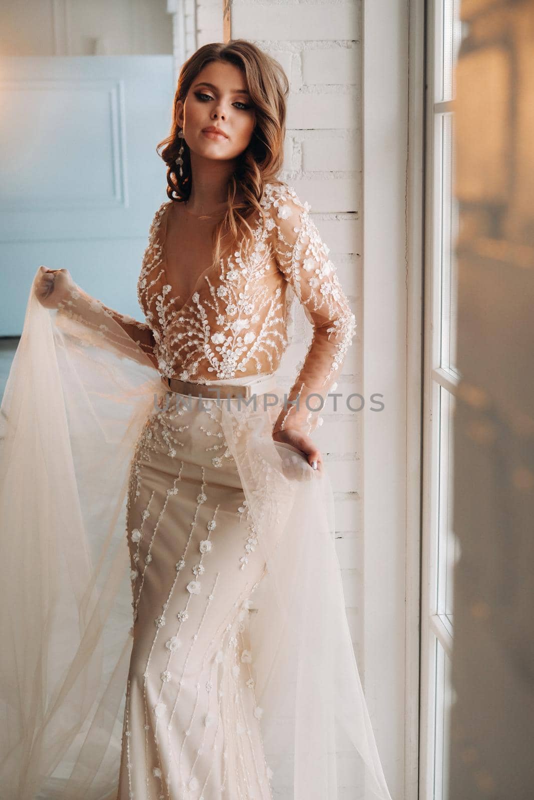 A luxurious bride in a wedding dress in the morning in her interior by Lobachad