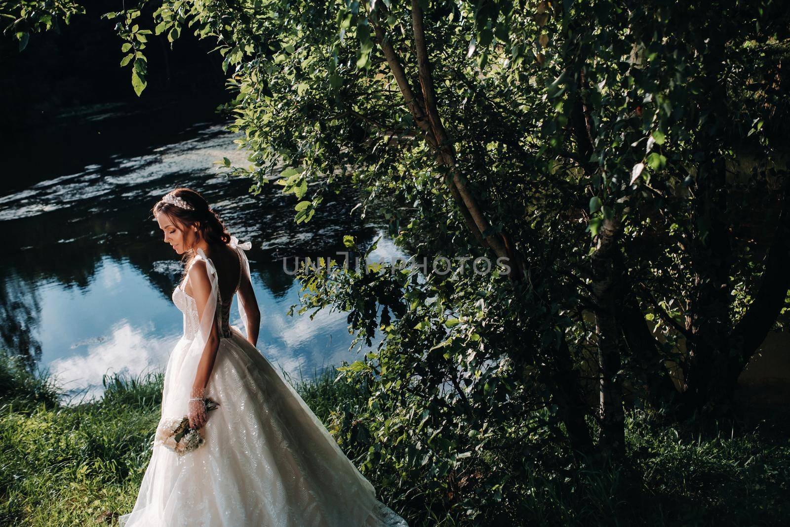 portrait of an elegant bride in a white dress with a bouquet in nature in a nature Park.Model in a wedding dress and gloves and with a bouquet .Belarus.