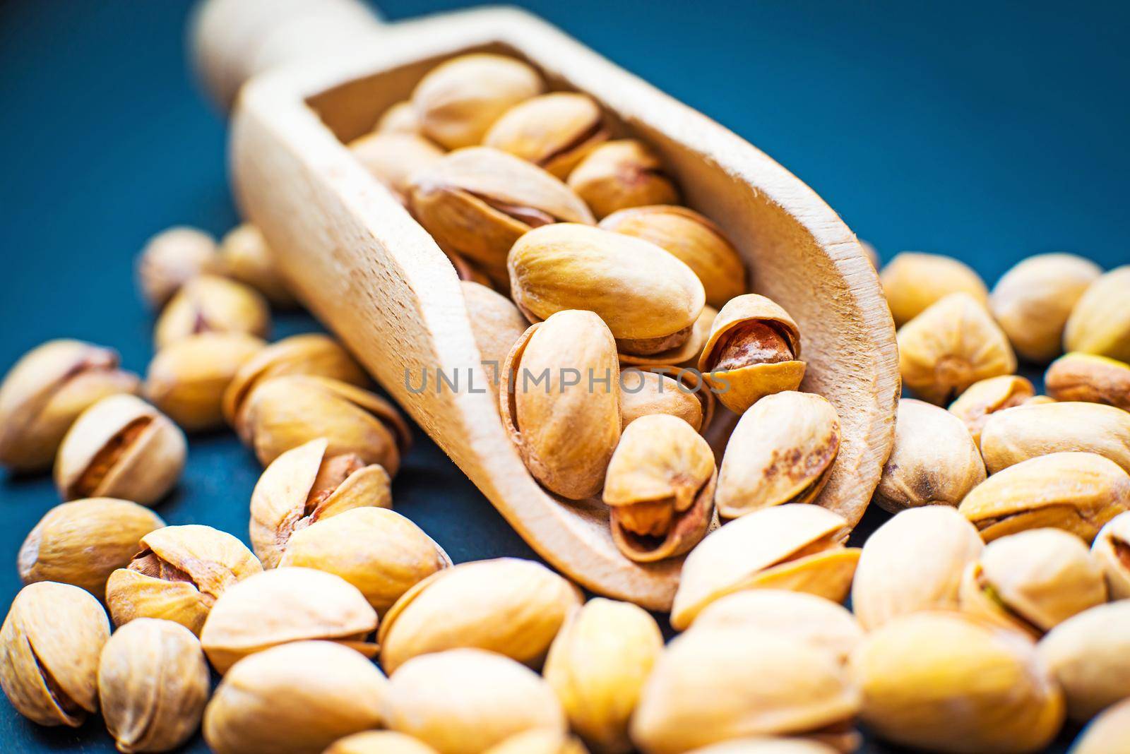 salt pistachios in a wooden spoon