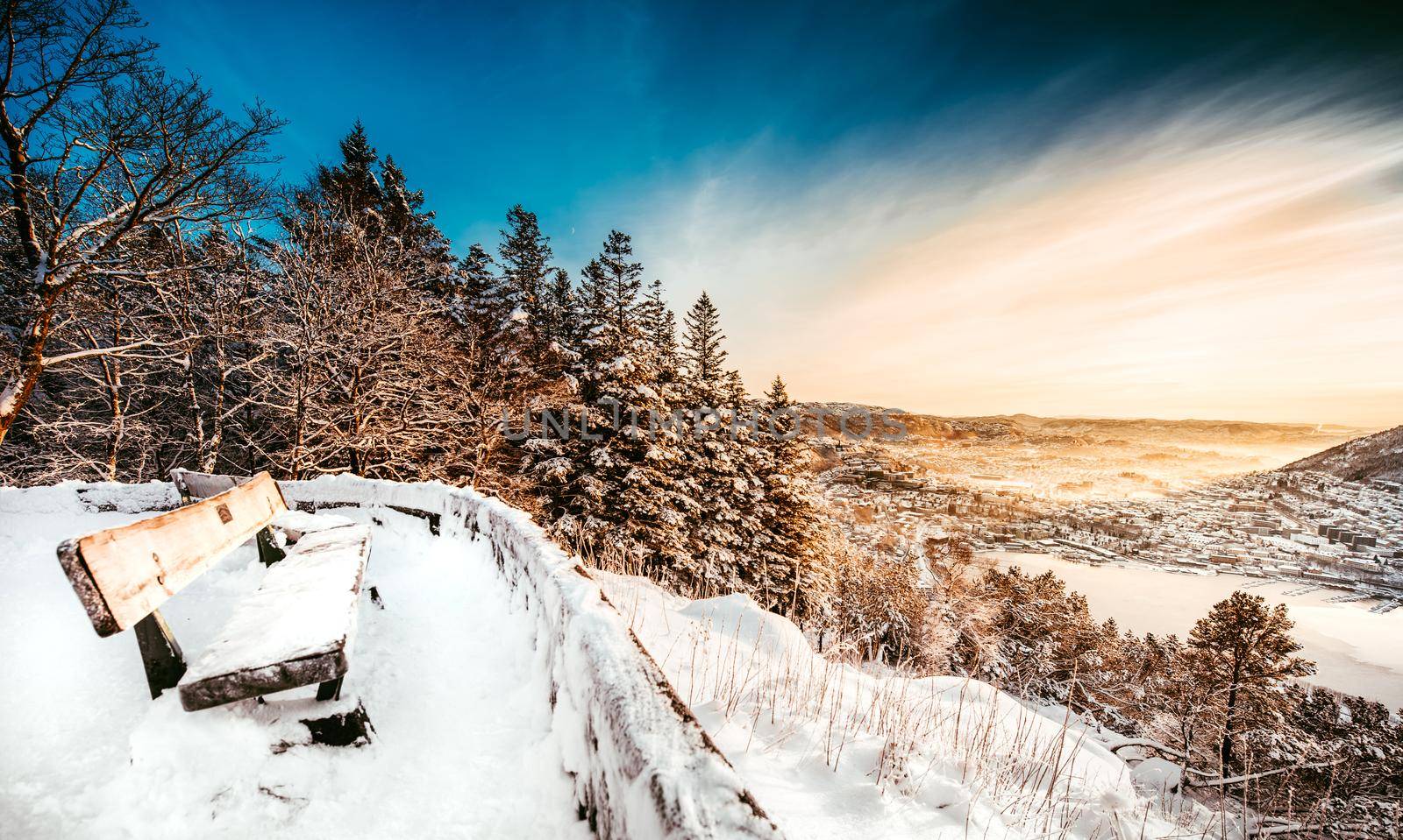 beautiful winter landscape with wooden bench from a mountain top