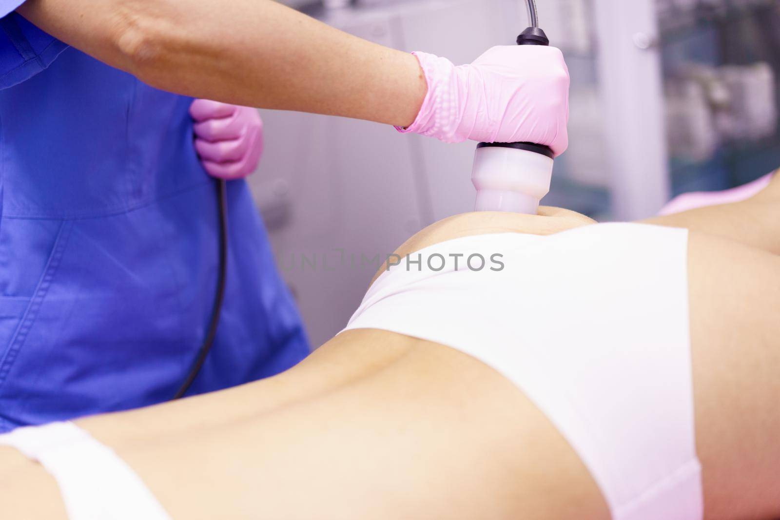 Middle-aged woman receiving anti-cellulite treatment with radiofrequency machine in an aesthetic clinic.