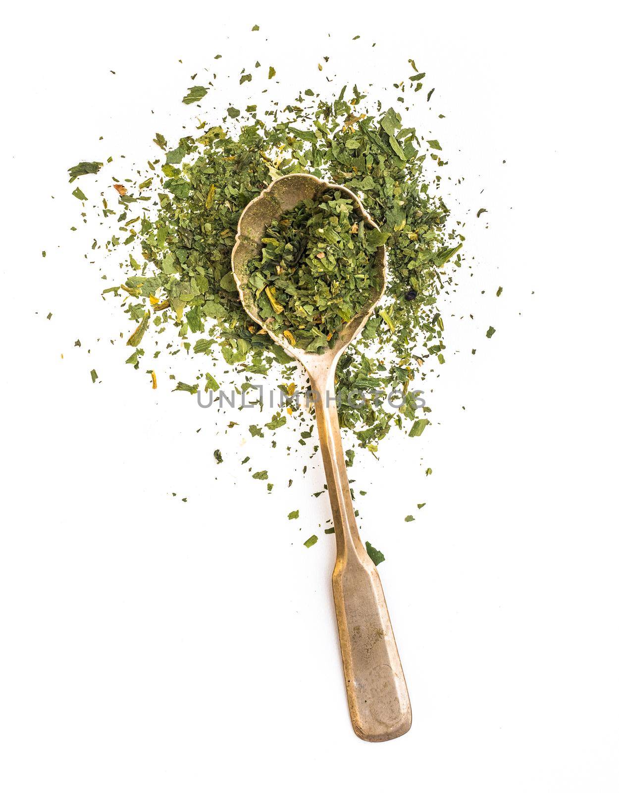 dried parsley in a spoon isolated on a white background