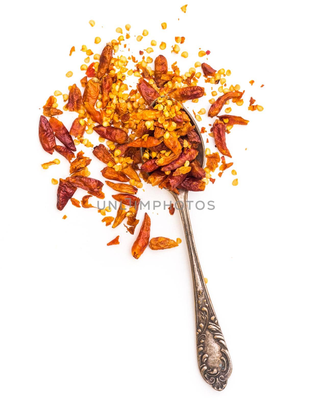 dried red peppers in a spoon isolated on a white background