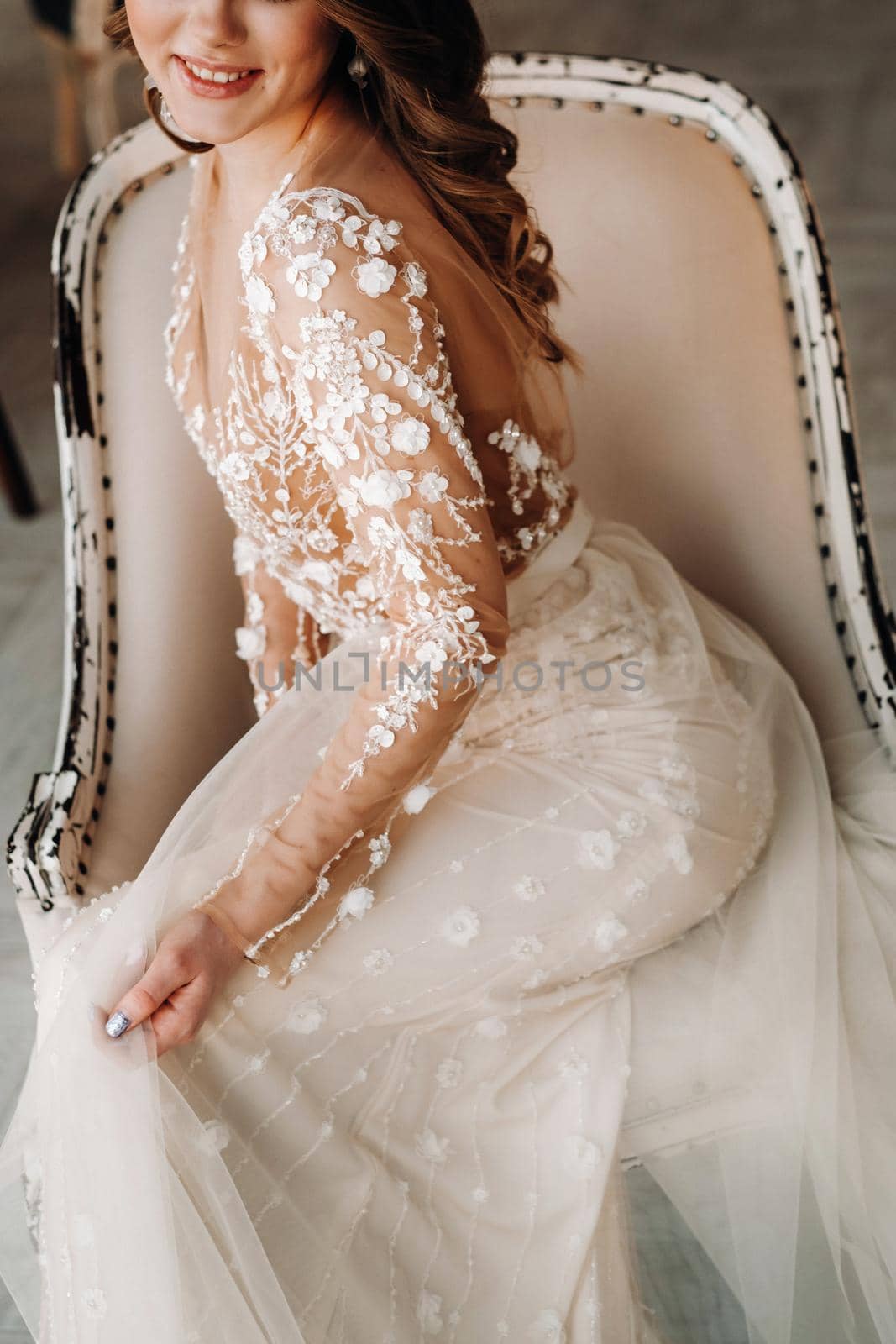 A luxurious bride in a wedding dress in the morning in her interior.