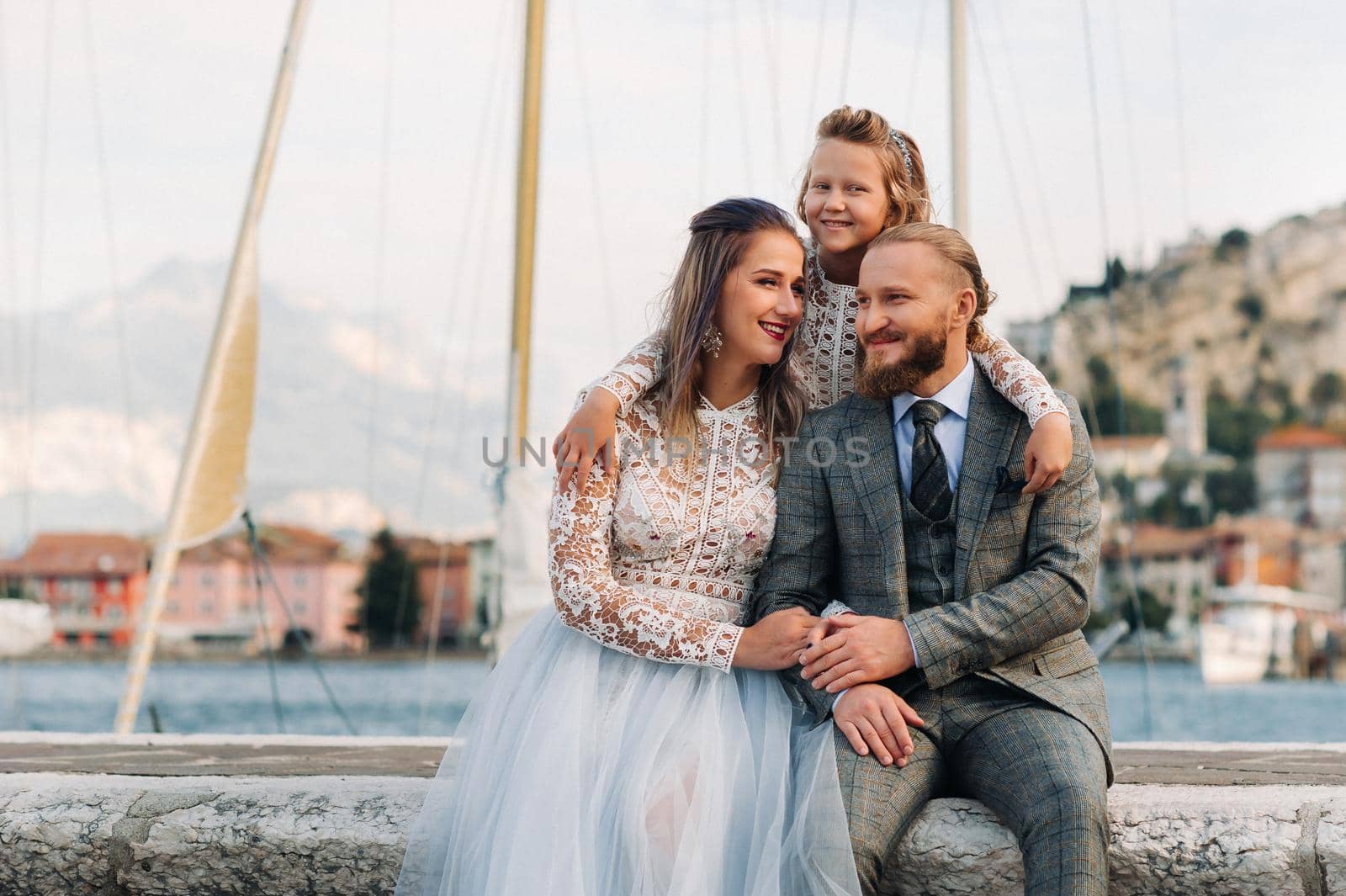 Italy, Lake Garda. Beautiful family on the shores of lake Garda in Italy at the foot of the Alps. Father, mother and daughter in Italy.