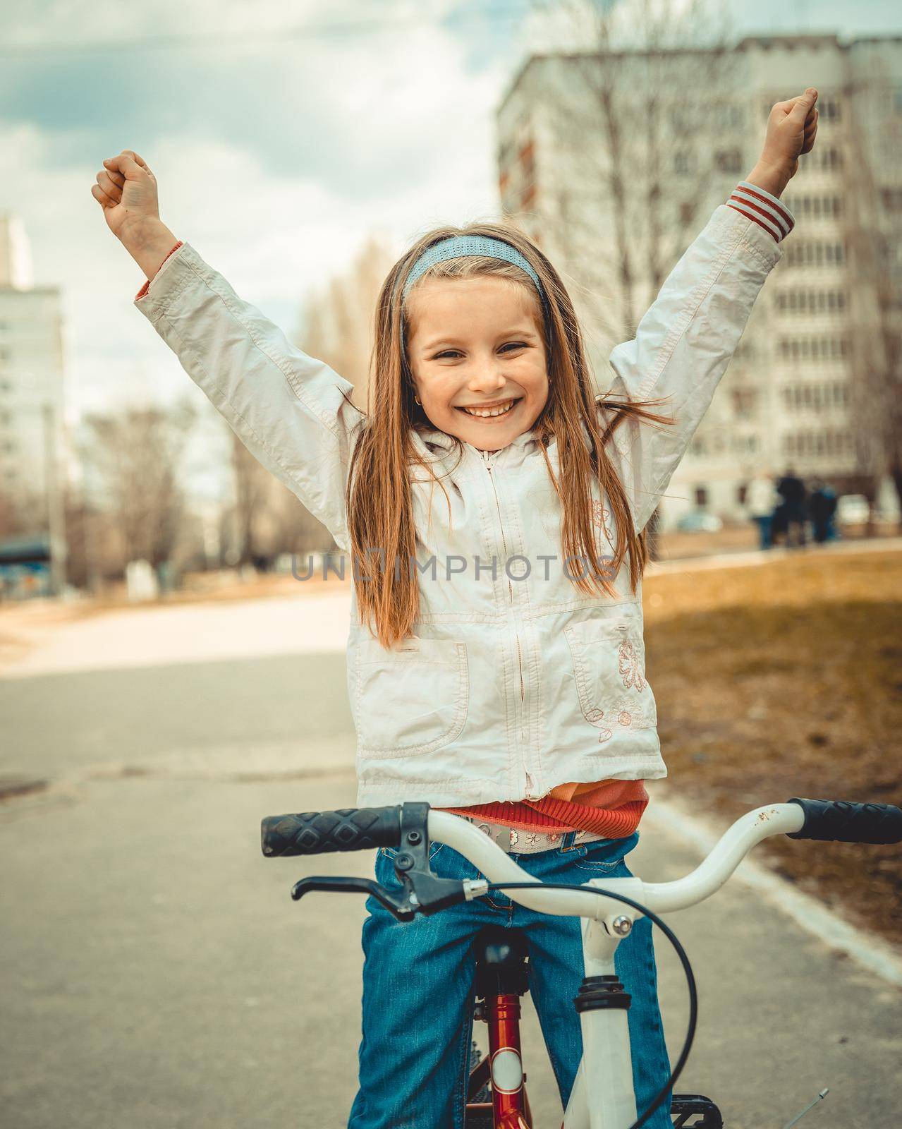 Little girl on a bicycle in summer park