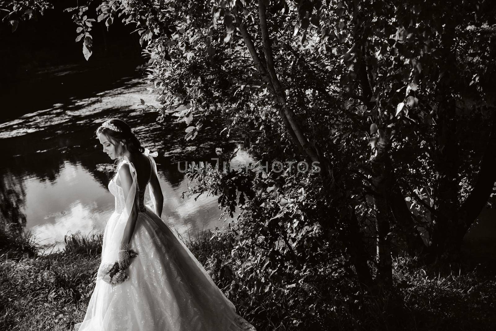 portrait of an elegant bride in a white dress with a bouquet in nature in a nature Park.Model in a wedding dress and gloves and with a bouquet .Belarus by Lobachad