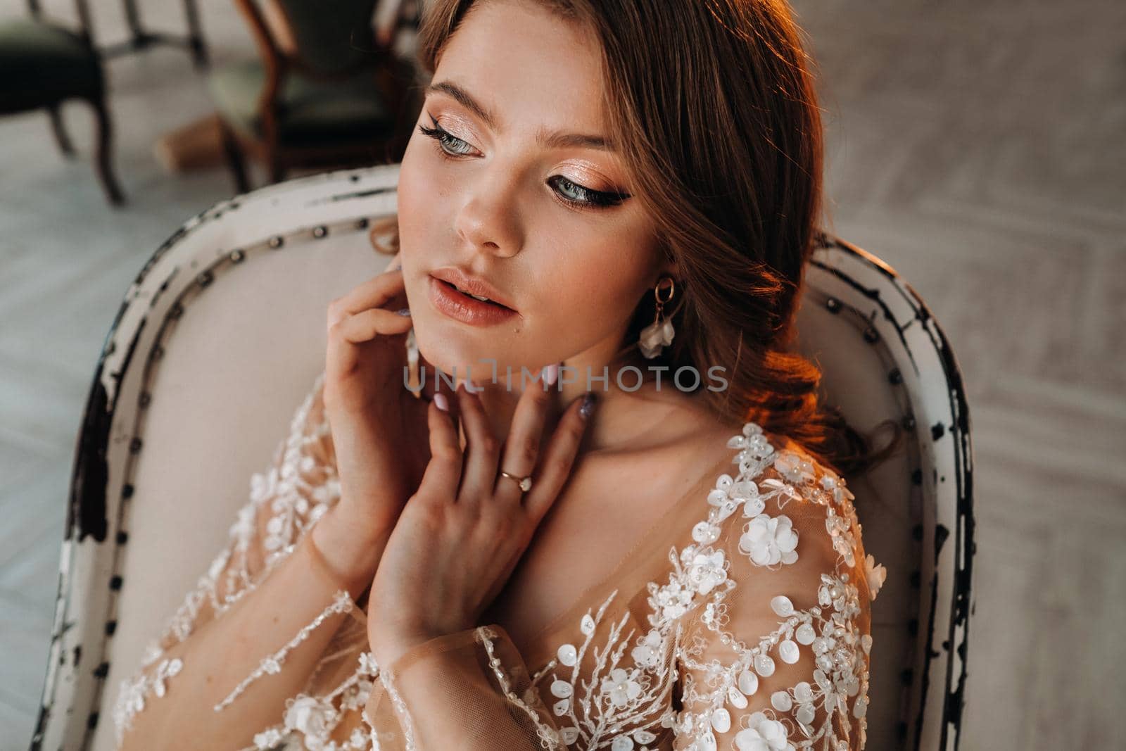 Close-up portrait of a luxurious bride in a wedding dress in the morning in her interior by Lobachad