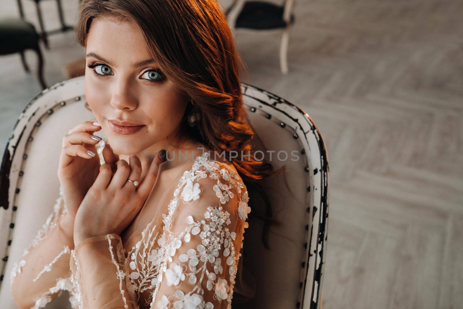 Close-up portrait of a luxurious bride in a wedding dress in the morning in her interior.