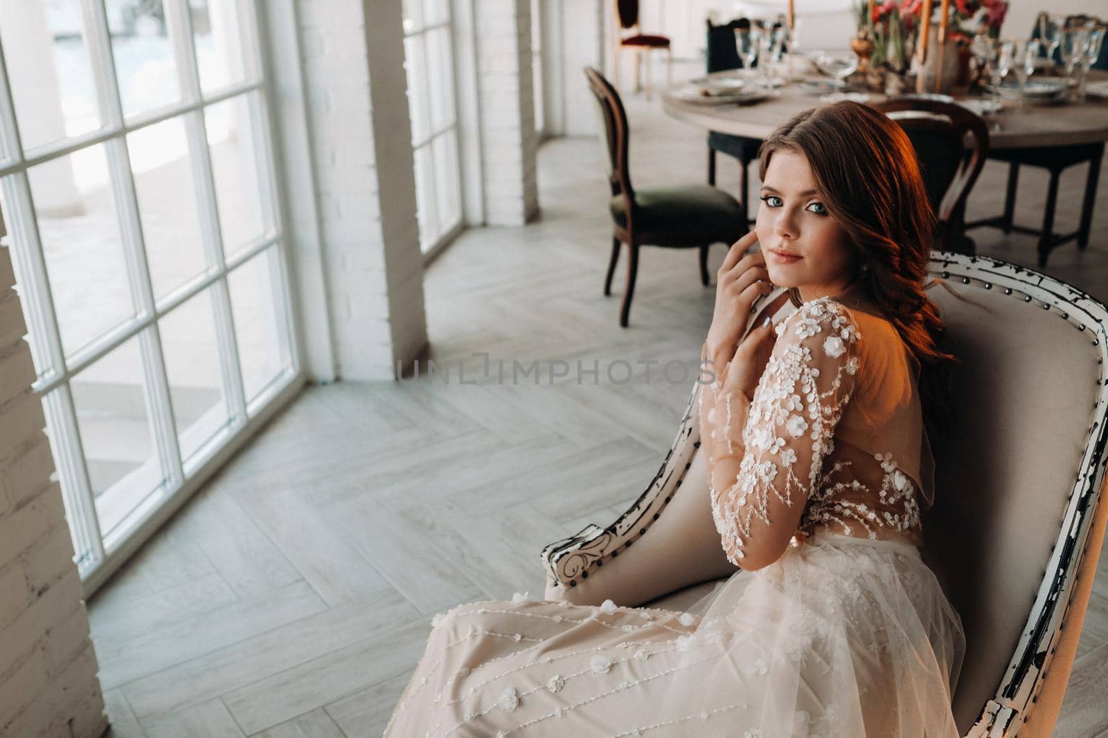 A luxurious bride in a wedding dress in the morning in her interior.