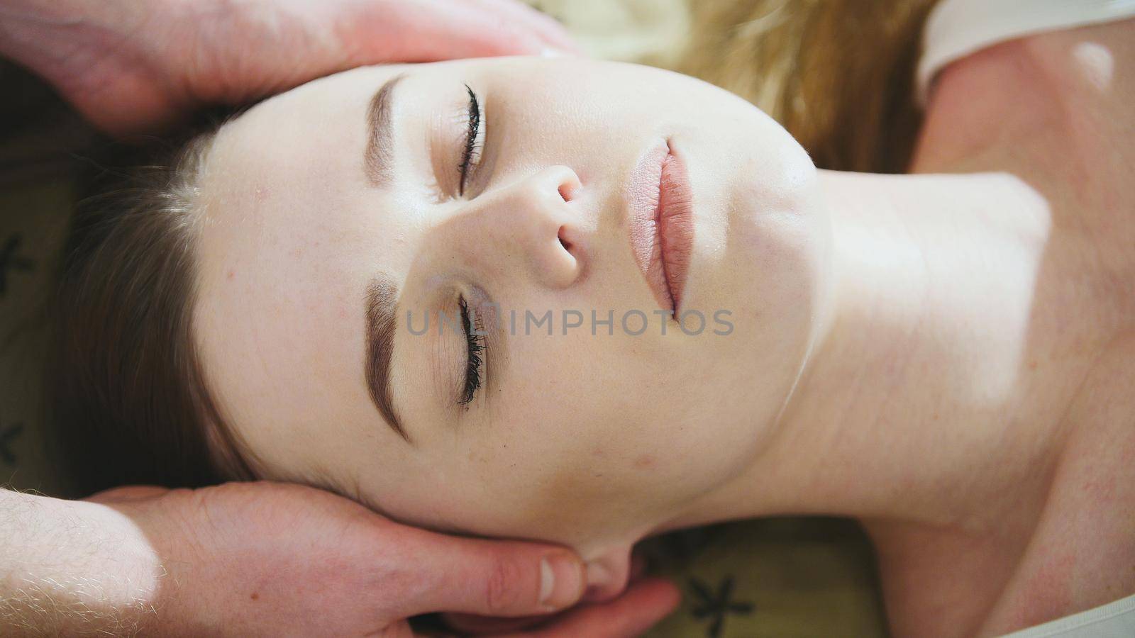 Thai massage session for head and face of beautiful lady, close up