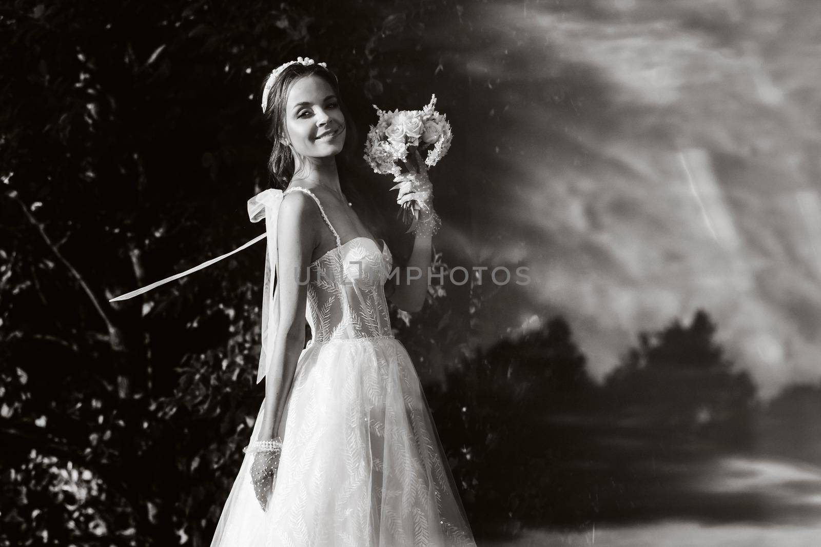 portrait of an elegant bride in a white dress with a bouquet in nature in a nature Park.Model in a wedding dress and gloves and with a bouquet .Belarus.