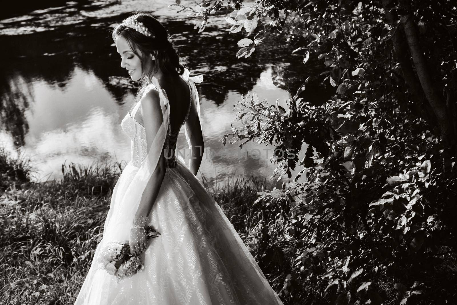 portrait of an elegant bride in a white dress with a bouquet in nature in a nature Park.Model in a wedding dress and gloves and with a bouquet .Belarus by Lobachad