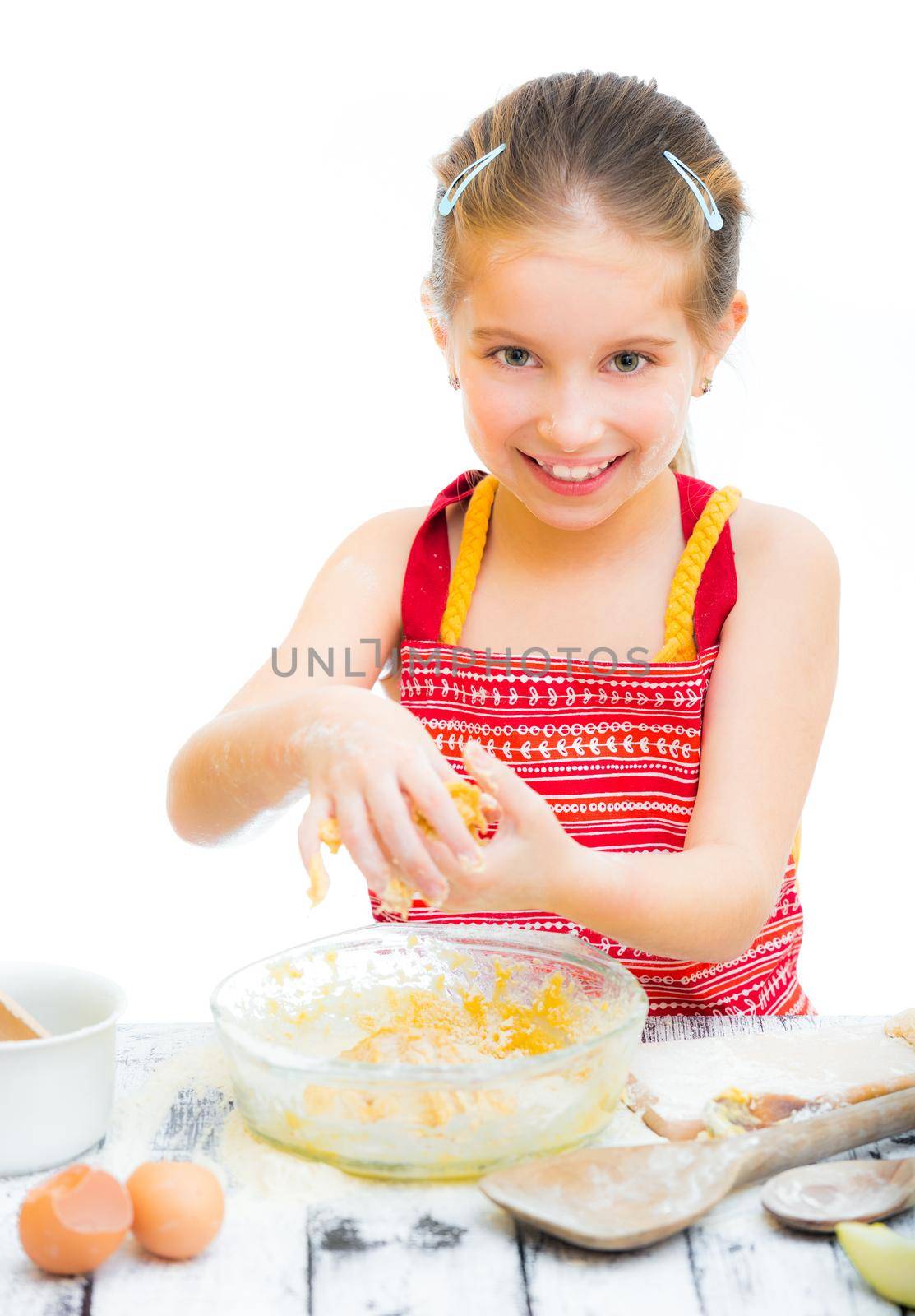 cutre little girl making dough, on a white background