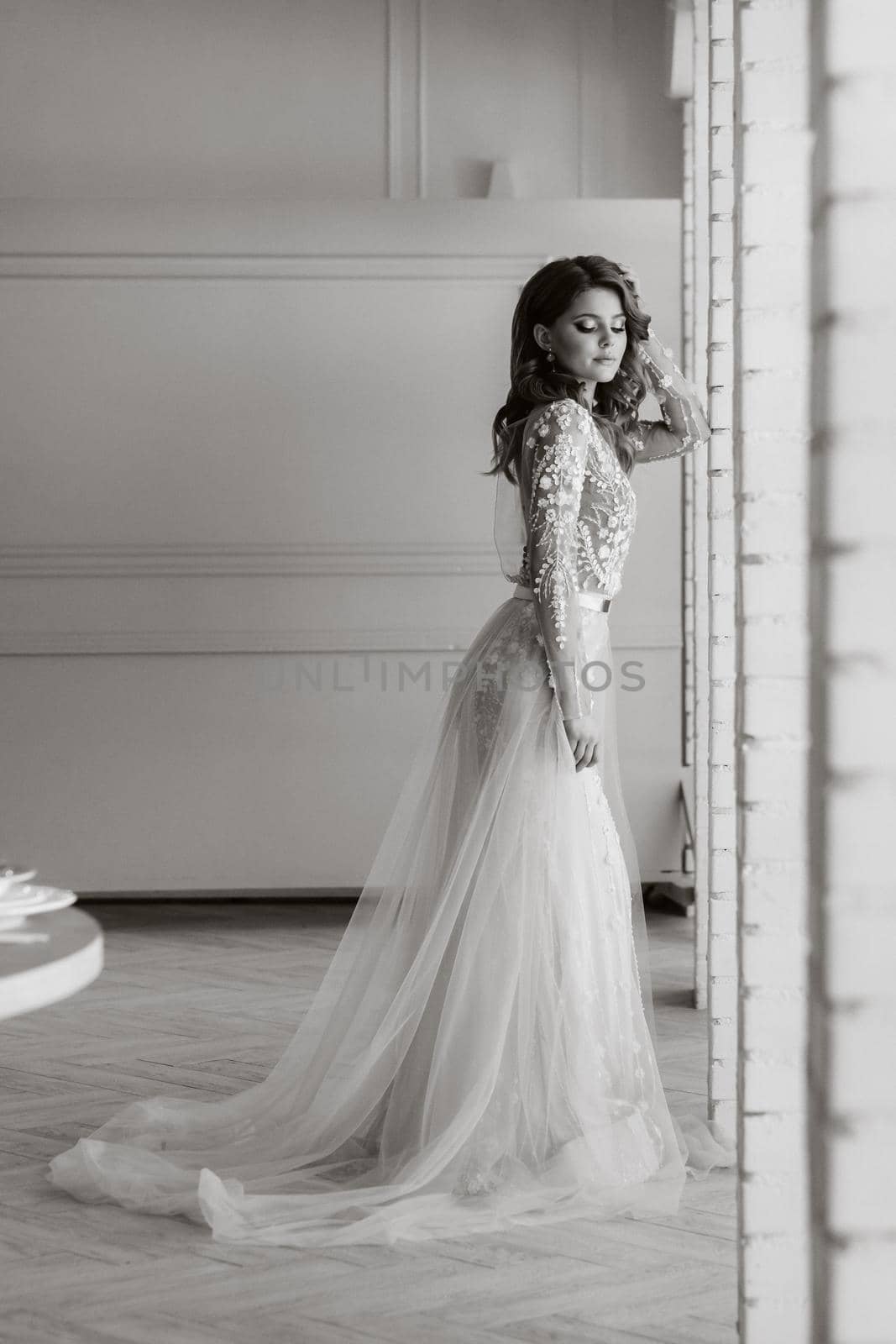 A luxurious bride in a wedding dress in the morning in her interior.Black and white photo.