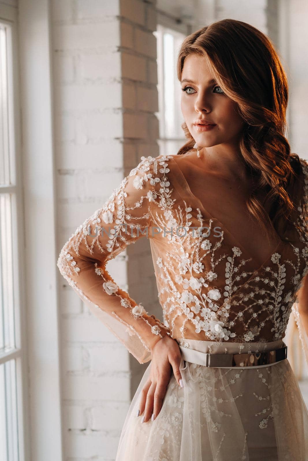 A luxurious bride in a wedding dress in the morning in her interior.