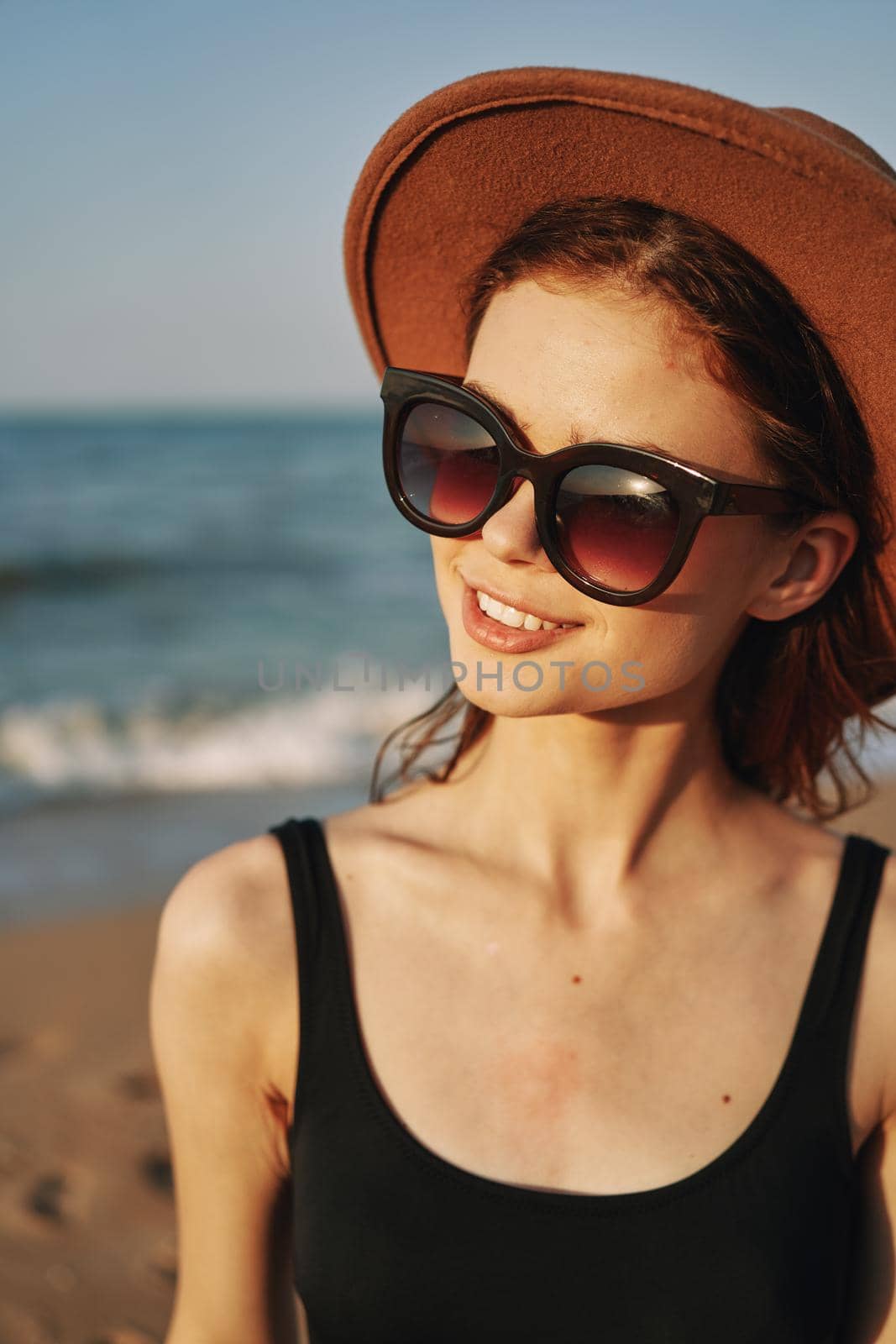 pretty woman in hat and sunglasses on the beach walk sun. High quality photo