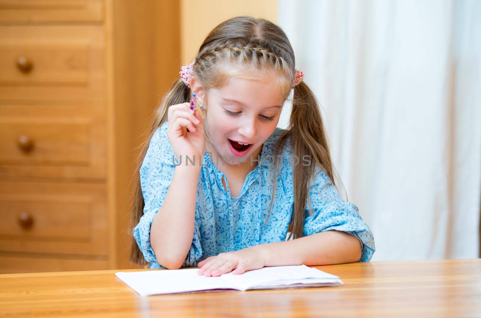 Cute little girl studying at home and smiling