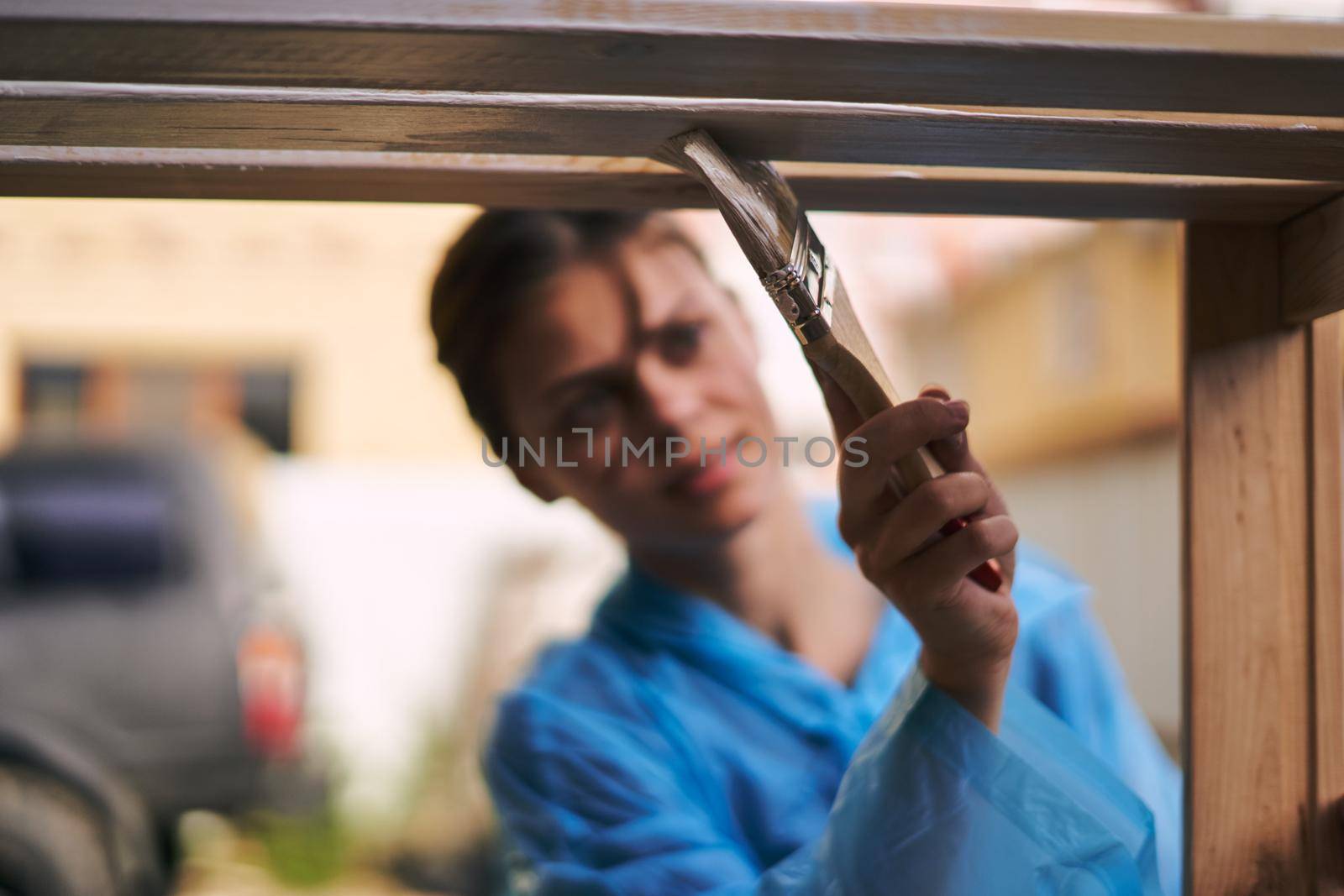 woman paints wood painter repair protective suit. High quality photo