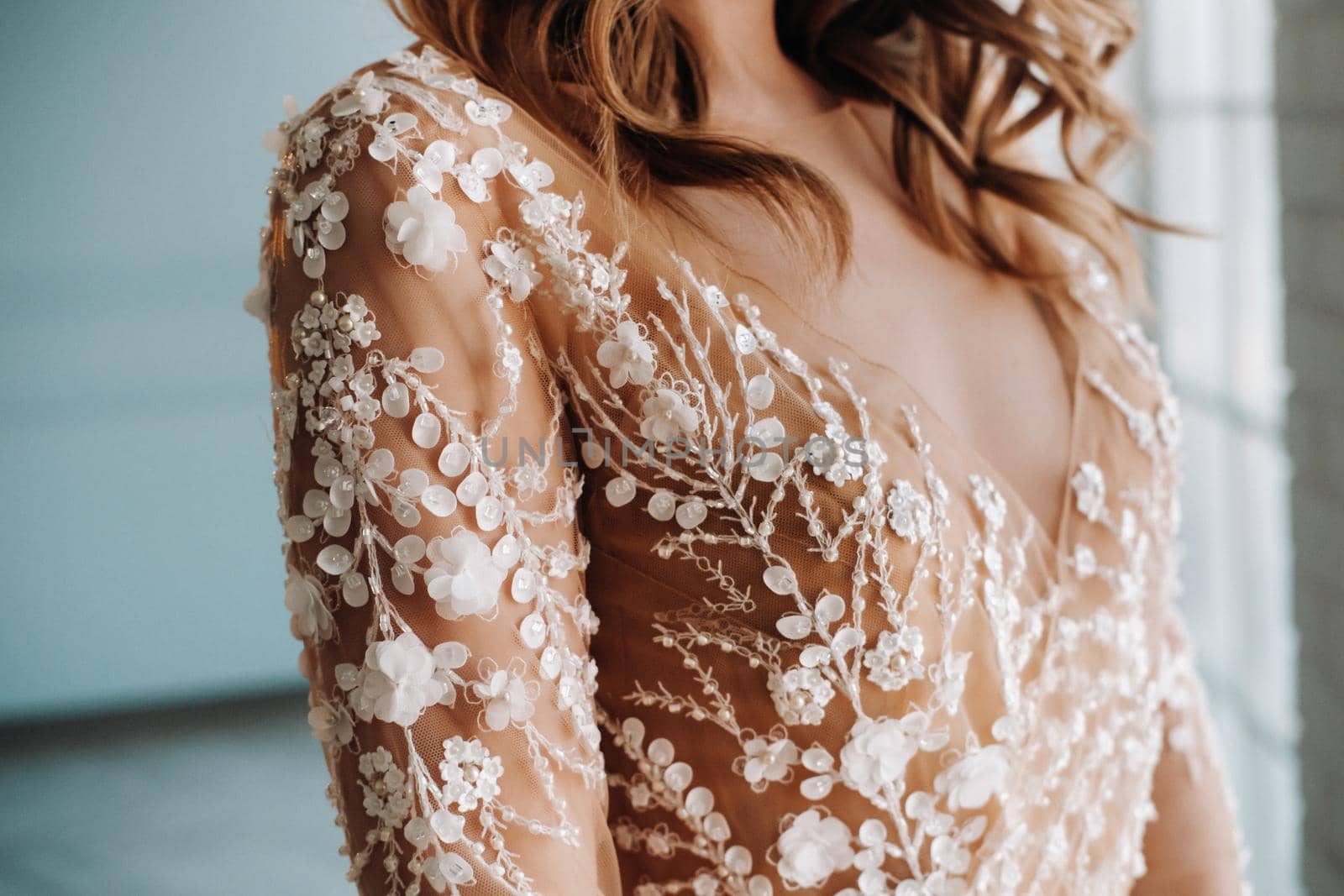 A luxurious bride in a wedding dress in the morning in her interior.