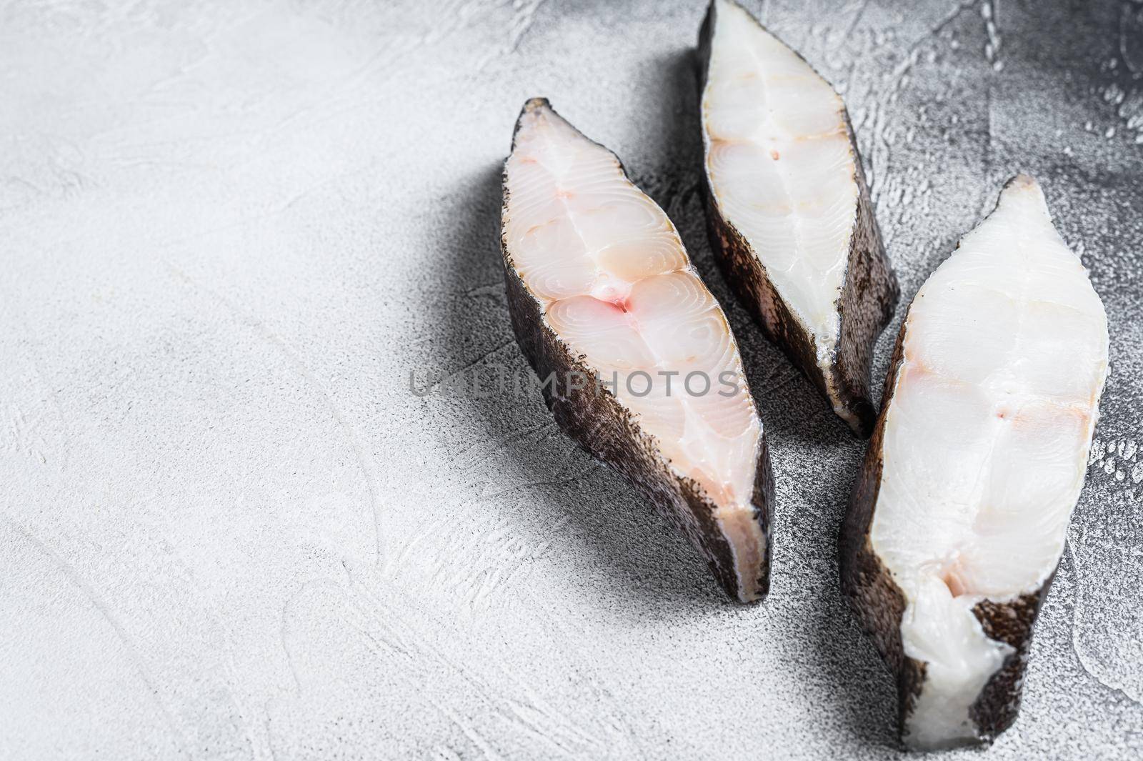 Raw fresh steak fish halibut on the stone table. White background. Top view. Copy space by Composter