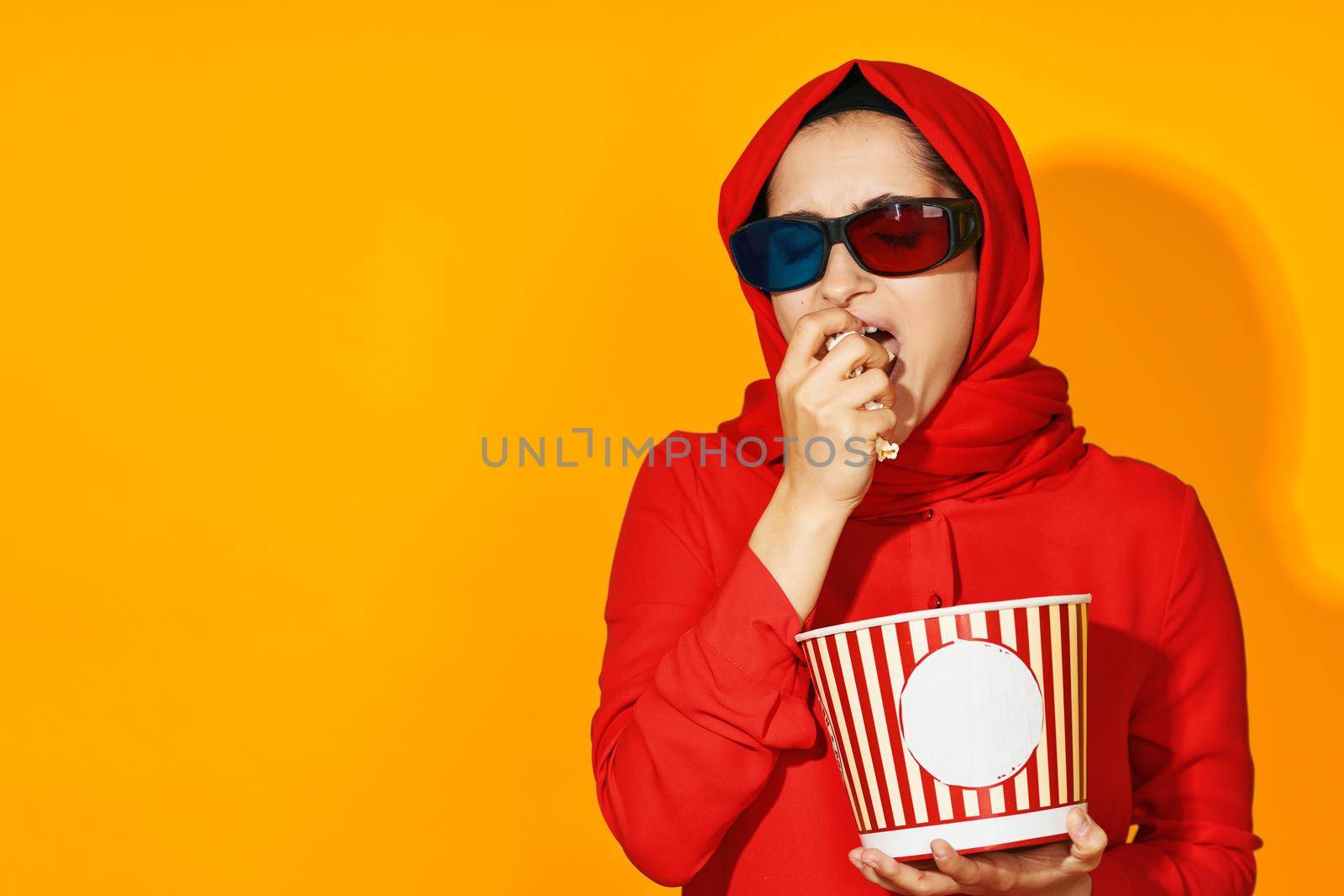 woman in red hijab 3d glasses technology watching movie popcorn yellow background by Vichizh