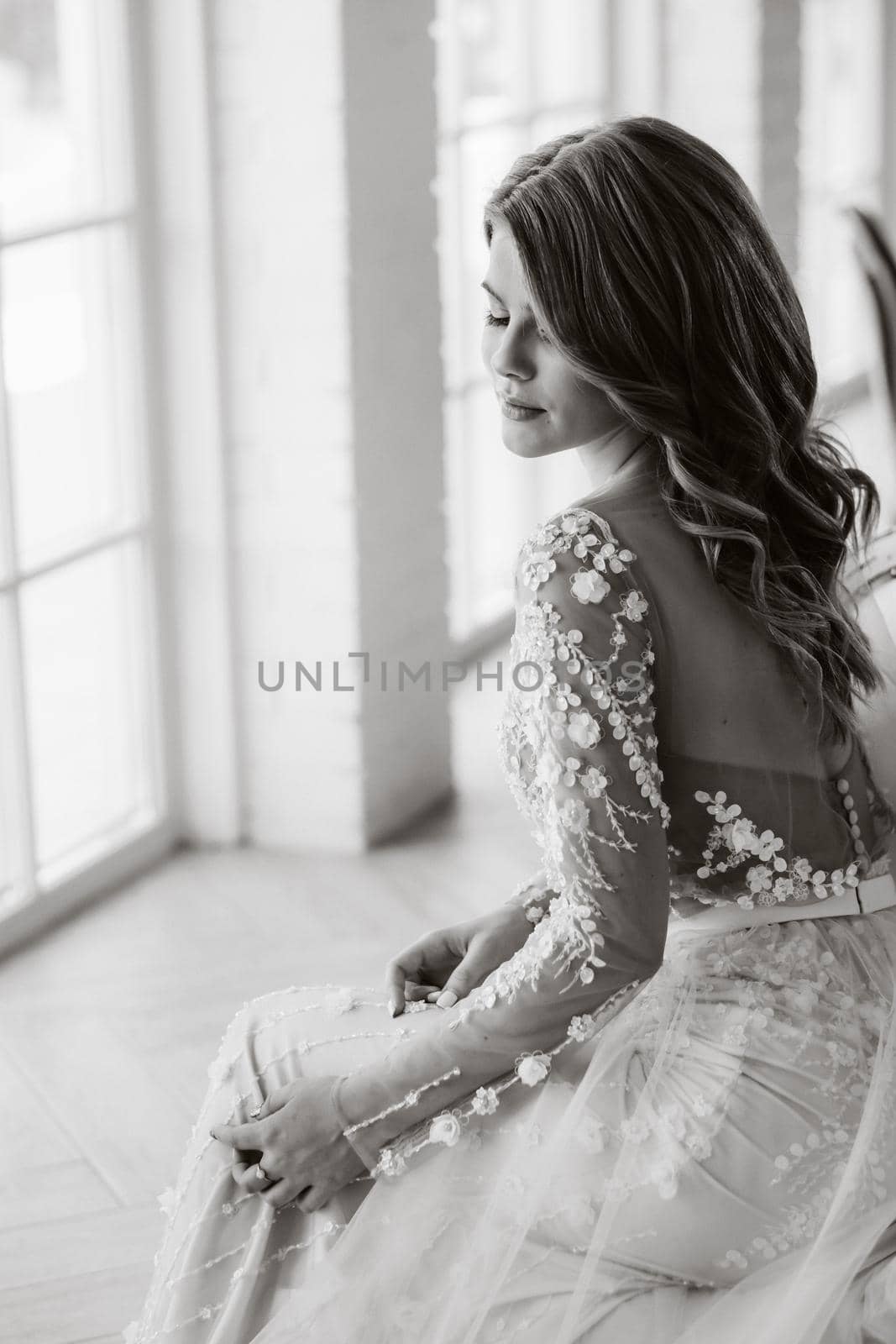 A luxurious bride in a wedding dress in the morning in her interior.Black and white photo.