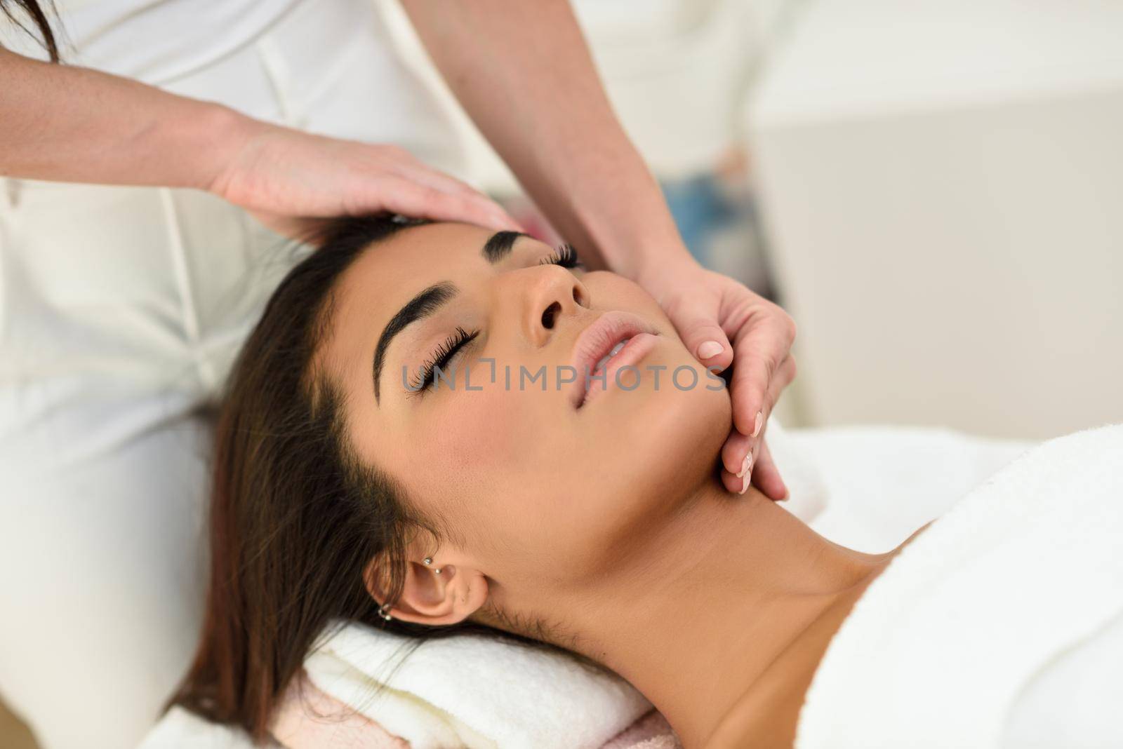 Woman receiving head massage in spa wellness center. by javiindy