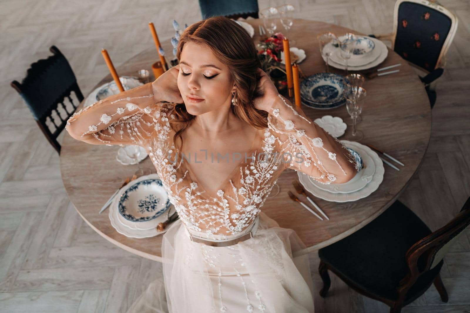 A luxurious bride in a wedding dress in the morning in her interior.