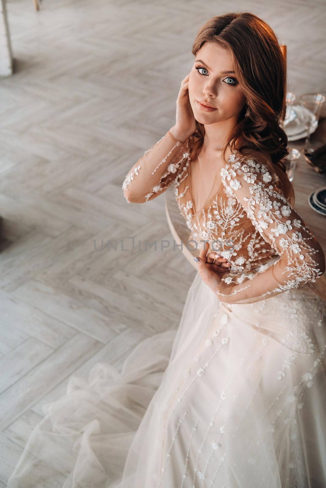 A luxurious bride in a wedding dress in the morning in her interior.