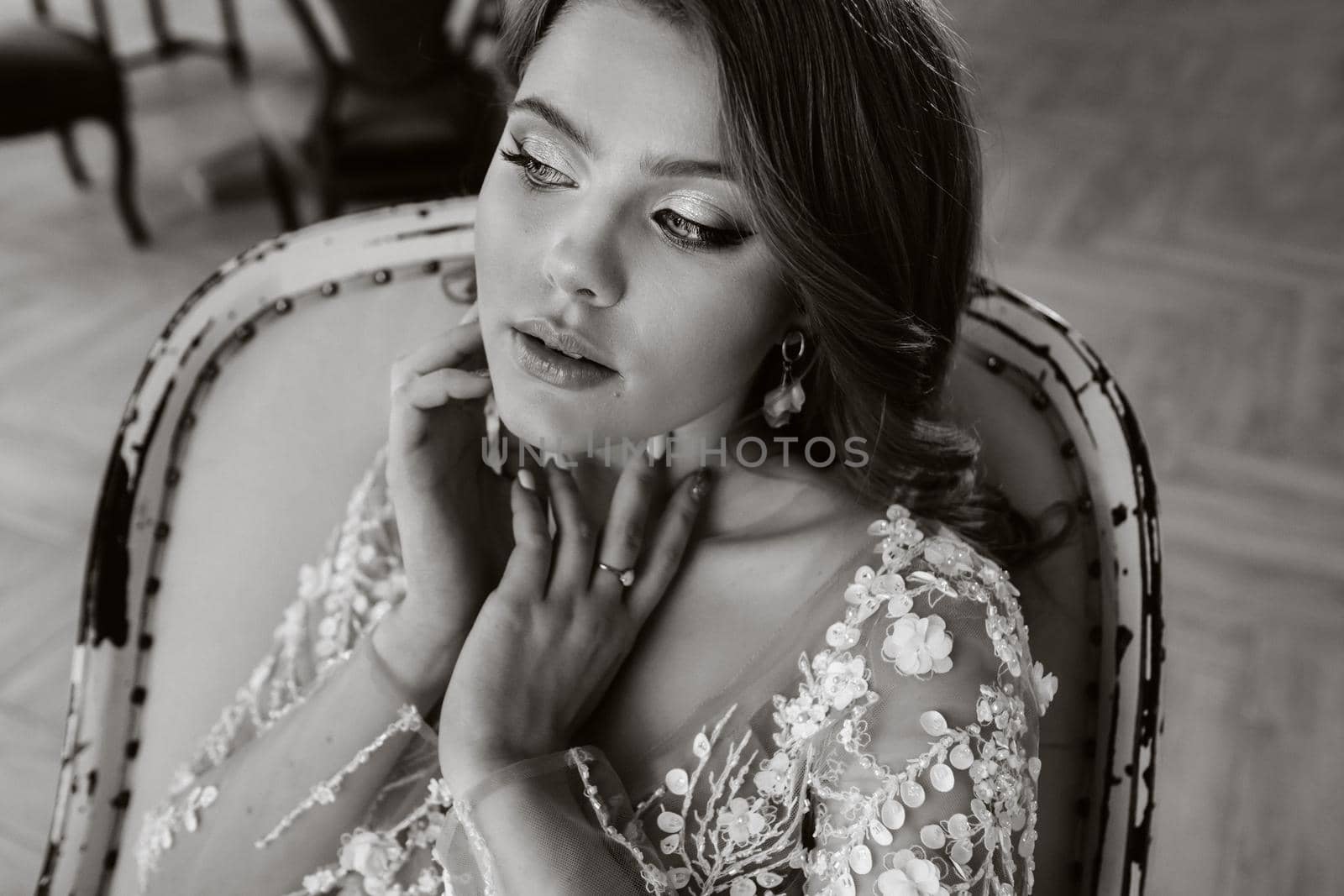 Close-up portrait of a luxurious bride in a wedding dress in the morning in her interior.black and white photo.