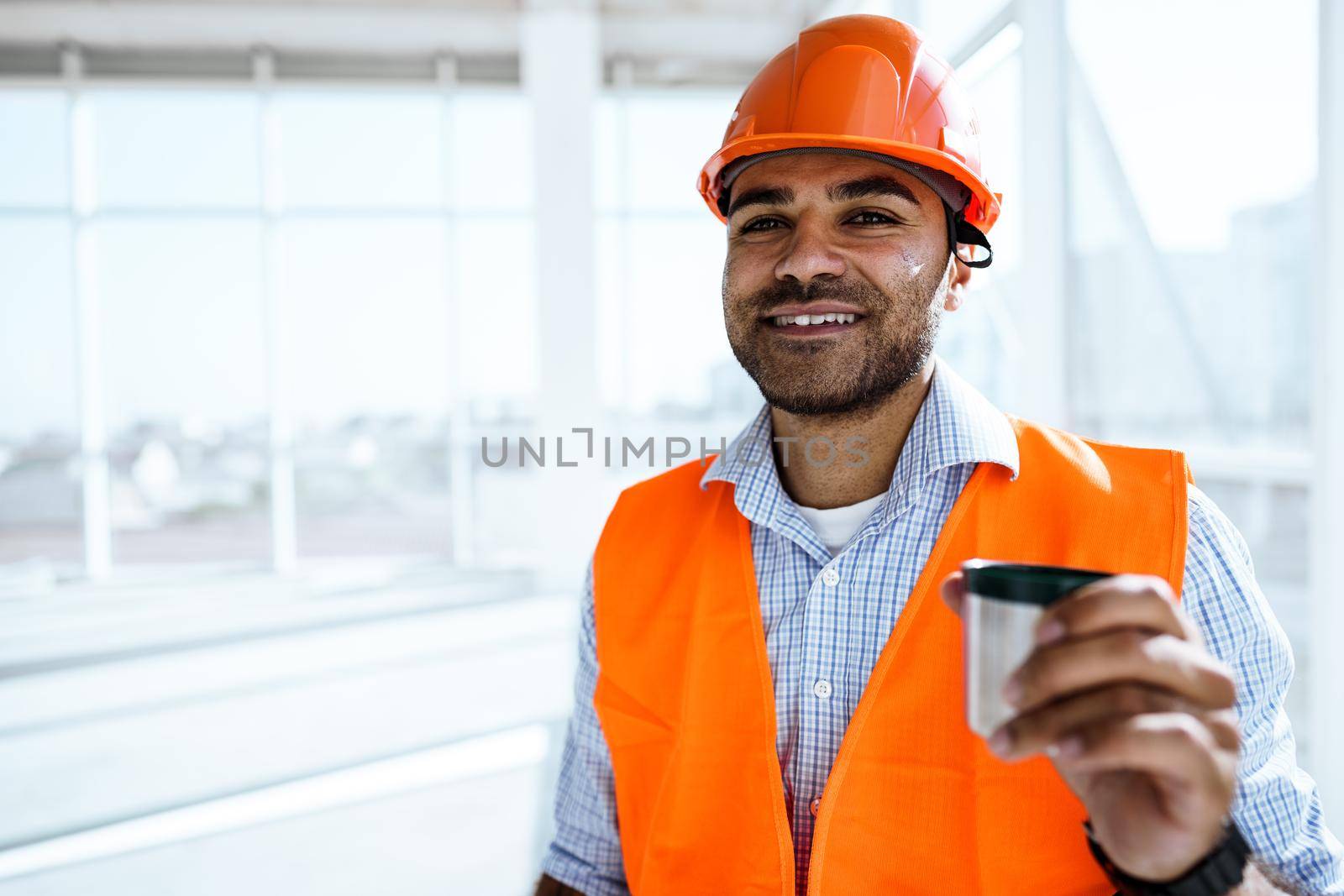 Portrait of a man worker in workwear on a break drink coffee and have rest, close up