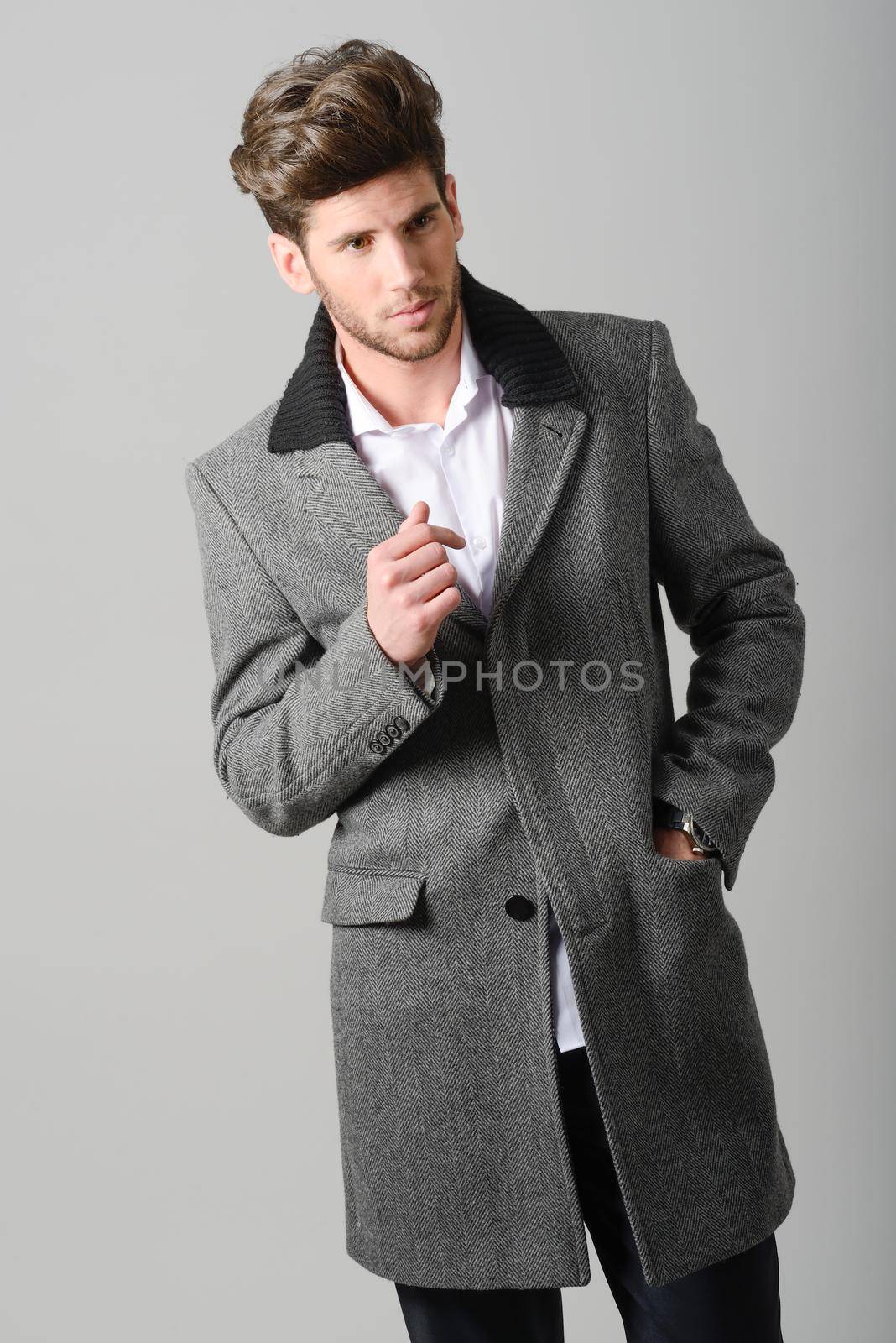 Portrait of handsome man, model of fashion, wearing coat. Studio shot