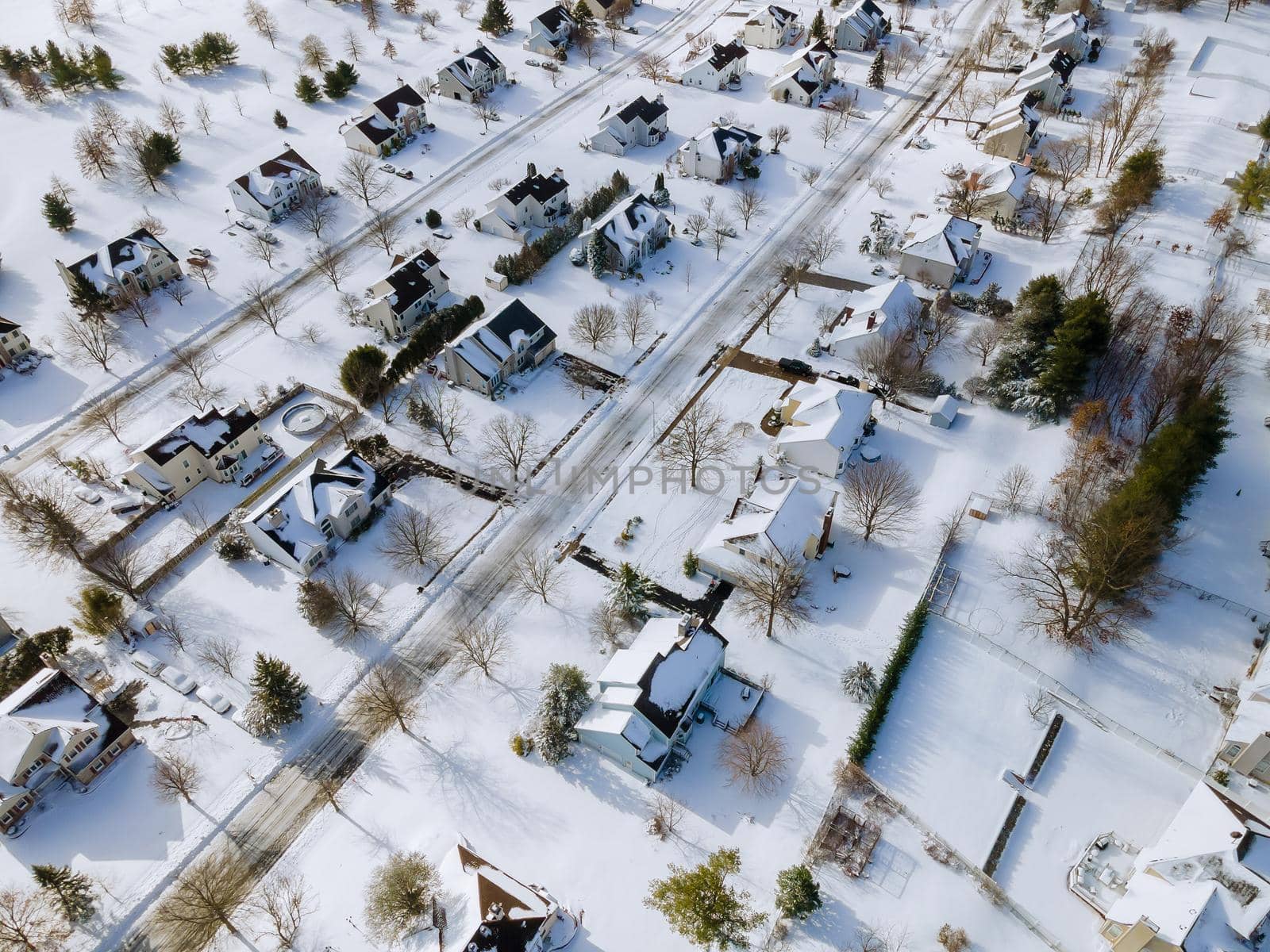 American town small home complex of a snowy winter on the residential streets after snowfall by ungvar