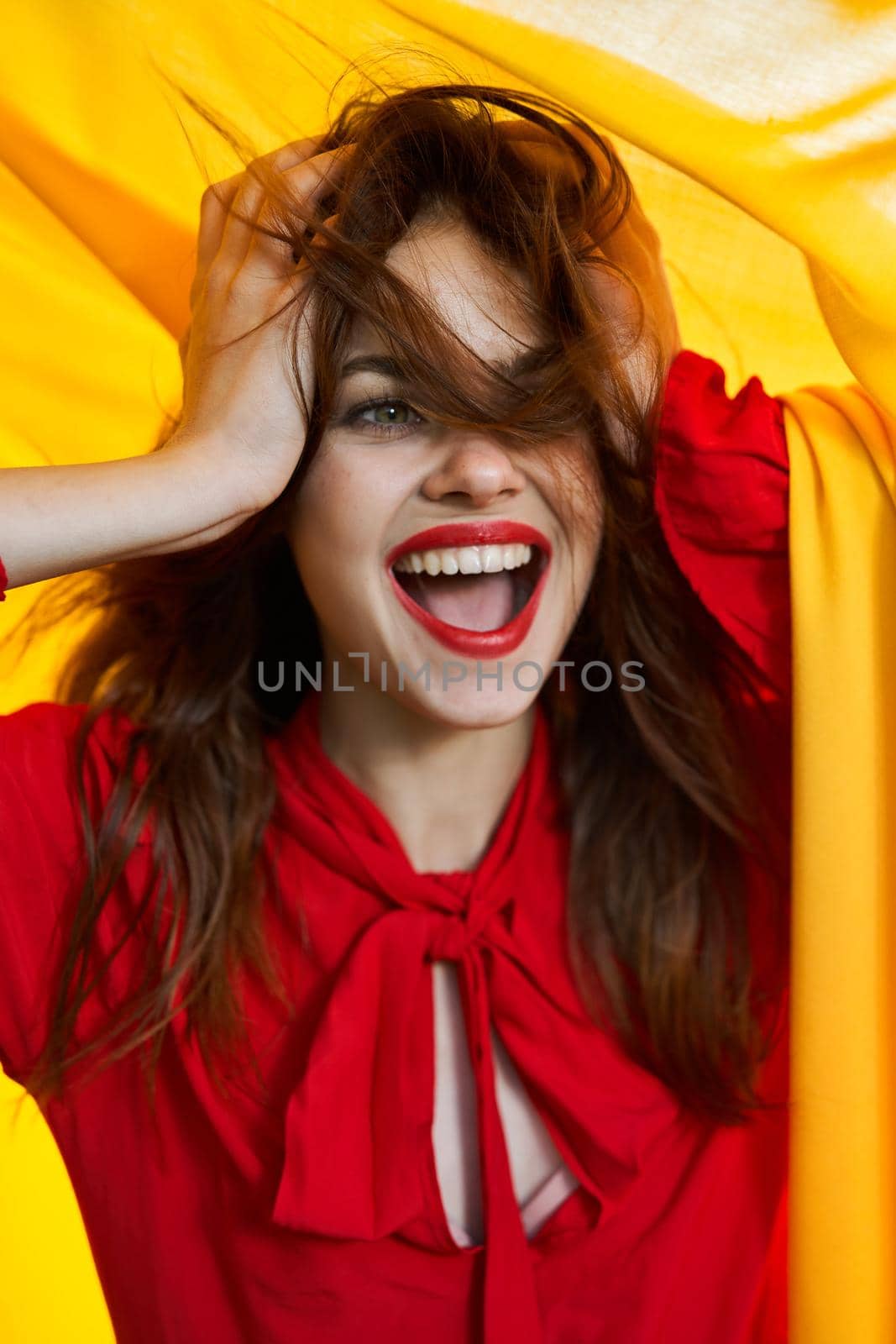 cheerful woman in red dress makeup yellow cloth posing. High quality photo